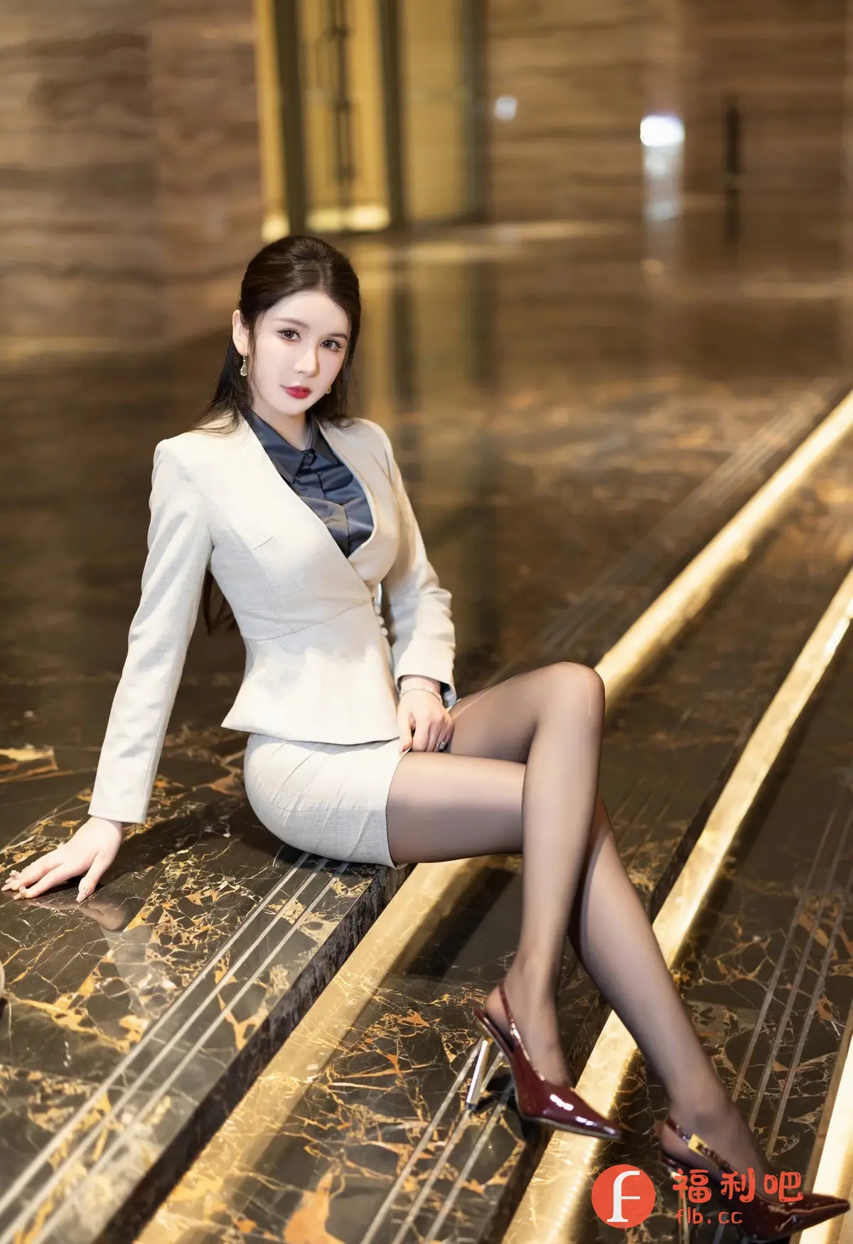 描述：这位迷人的亚洲女性身着剪裁合身的米色套装，优雅地坐在大理石台阶上，让人心动。她深色的衬衫与套装形成对比，衬托出她精致的五官和精心打理的发型。黑色丝袜包裹着修长的双腿，延伸至一双时尚的勃艮第高跟鞋中，更显性感魅力。她自信的姿势和迷人的眼神散发出一种不容抗拒的吸引力，吸引着人们的目光，让人不禁想了解更多关于她的故事。这种优雅、性感和自信的完美结合，让这位女士成为了一个令人难忘的视觉焦点。

识别内容：一位身穿套装的亚洲女性坐在大理石台阶上。