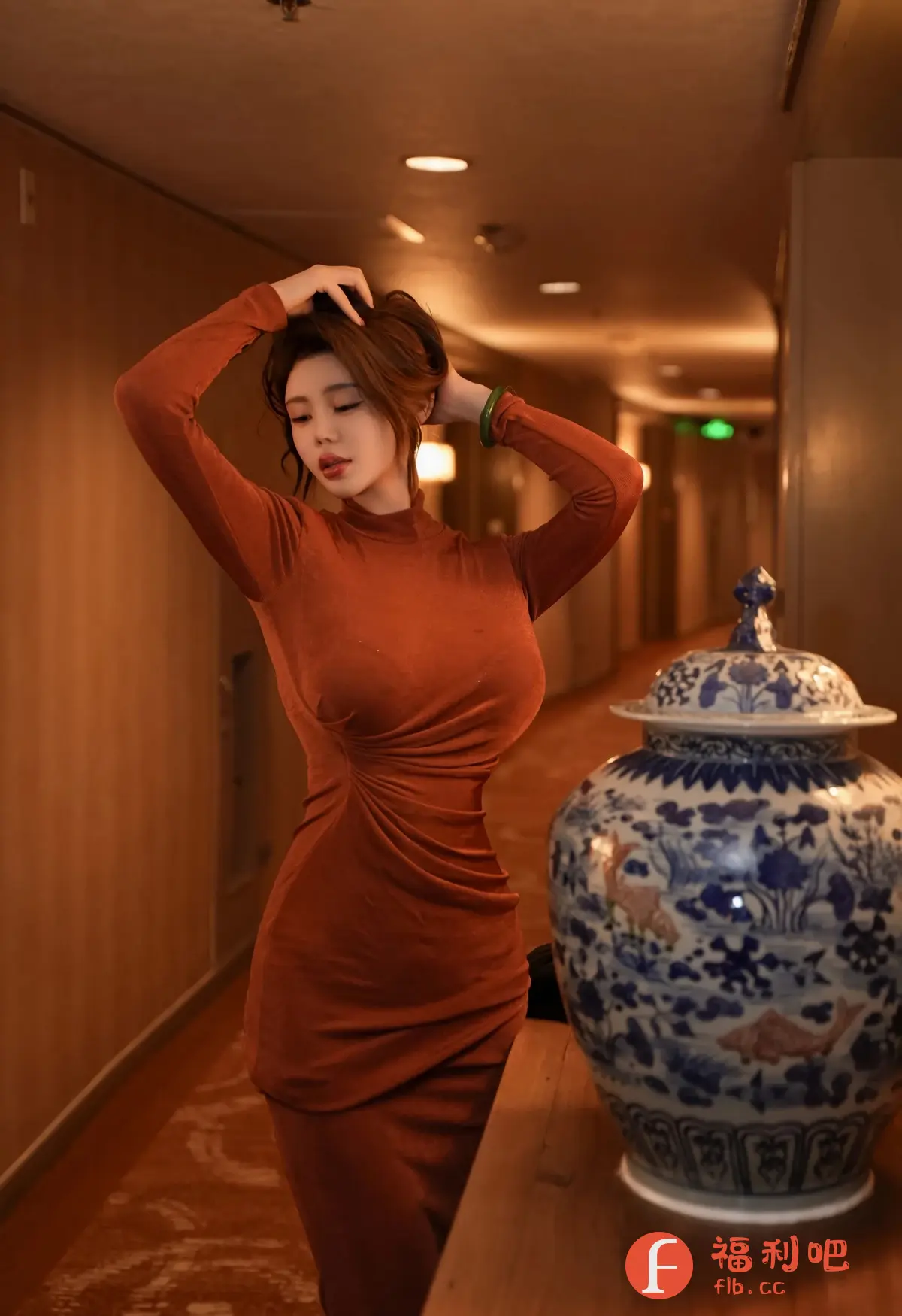 描述:照片中,一位身材婀娜的亚洲女性身穿一件橘红色紧身连衣裙,优雅地站在室内。她双手举过头顶,似乎正在整理头发,露出精致的侧颜和光滑的脖颈。连衣裙的设计凸显了她的身材曲线,尽显成熟女性的魅力。
背景是一个走廊,灯光柔和,营造出温馨的氛围。在她身旁,摆放着一个精美的青花瓷罐,罐身上的图案栩栩如生,为画面增添了一丝古典韵味。整体构图简洁而富有层次感,色彩搭配温暖和谐,展现出女性的优雅和自信。这是一张具有艺术感的私房写真,捕捉了女性生活中不经意的美好瞬间。
