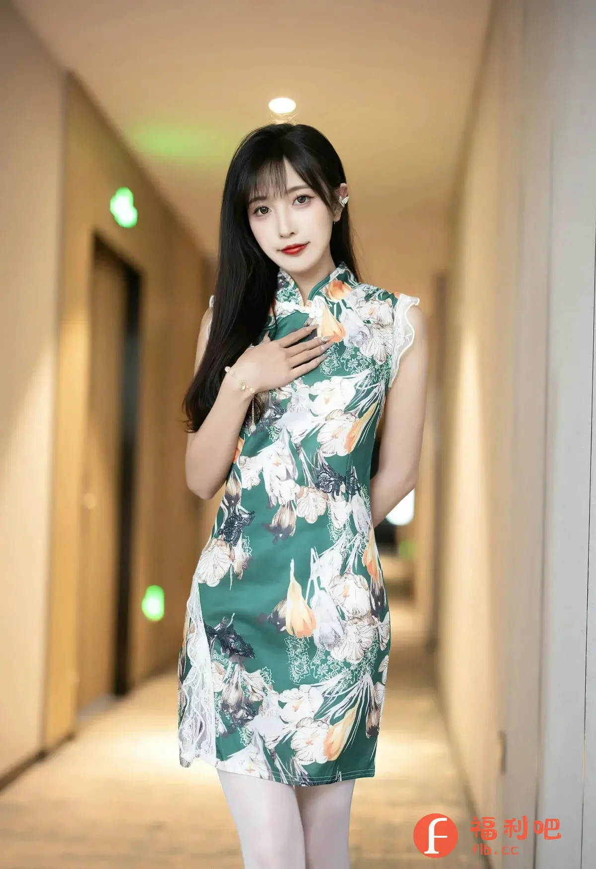 描述：照片中是一位年轻漂亮的亚洲女性，她身穿一件绿色的旗袍，旗袍上印有白色和橙色的花卉图案，领口是传统的立领设计，袖口和裙边都有精致的白色蕾丝边装饰。她长长的黑发柔顺地披在肩上，齐刘海凸显了她精致的五官，红唇明艳动人。她手腕上戴着一条细细的手链，右手轻轻地放在胸前，眼神温柔地看着镜头。

背景是一个走廊，光线柔和，营造出一种温馨的氛围。整体照片色彩明快，风格优雅，展现了女性的东方魅力。

照片中是一位年轻漂亮的亚洲女性，身穿绿色花卉旗袍，长发披肩，红唇明艳，背景为光线柔和的走廊。
