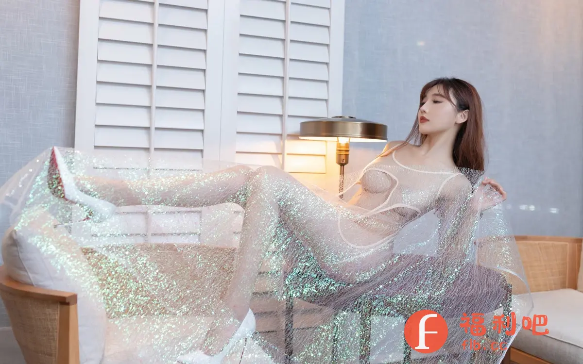 描述:这张私房写真展示了一位亚洲美女的性感与魅力。她斜躺在沙发上,身穿一件设计大胆、薄如蝉翼的透明纱裙,裙子上点缀着闪亮的装饰,在灯光下熠熠生辉,更显梦幻。纱裙巧妙地勾勒出她的身材曲线,隐约可见的肌肤增添了几分神秘和诱惑。她微微侧头,眼神妩媚动人,红唇娇艳欲滴,散发出成熟女性的韵味。背景是简洁的房间,白色的百叶窗和暖色调的灯光营造出温馨而私密的气氛,更突显出美女的性感与优雅。整体构图和谐,光影运用恰到好处,将女性的柔美与性感完美结合,令人赏心悦目。