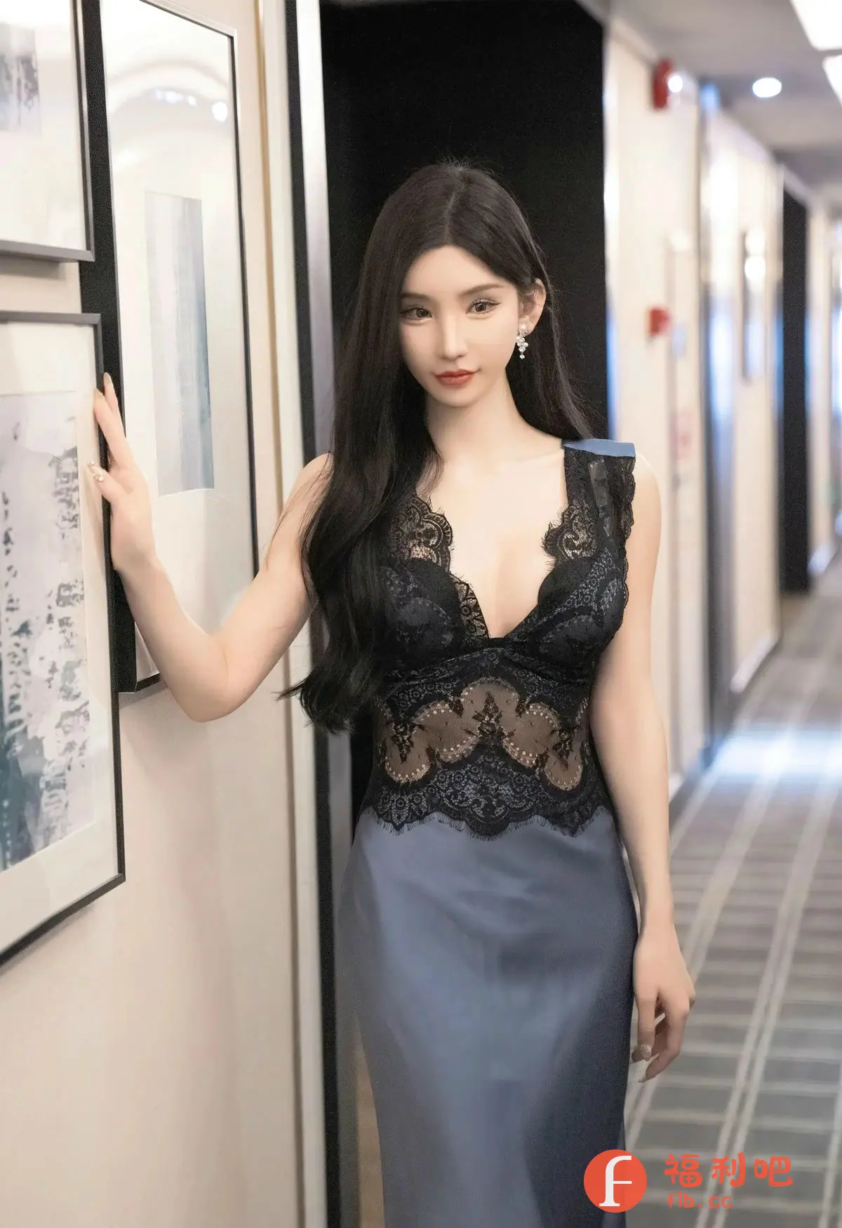 描述：照片中一位穿着性感睡衣的美女站在走廊里。她拥有一头乌黑亮丽的长发，精致的妆容凸显出她清秀的五官。她身穿一件黑色蕾丝拼接的睡衣，上半部分的设计大胆迷人，下半部分则是柔滑的丝绸质地，展现出她曼妙的身材曲线。她一只手轻轻搭在墙上的画框旁，眼神略带妩媚，营造出一种慵懒而性感的氛围。走廊的灯光柔和，背景则是一条通往深处的长廊，更增添了画面的意境。整体画面充满着时尚感和女性魅力，令人赏心悦目。