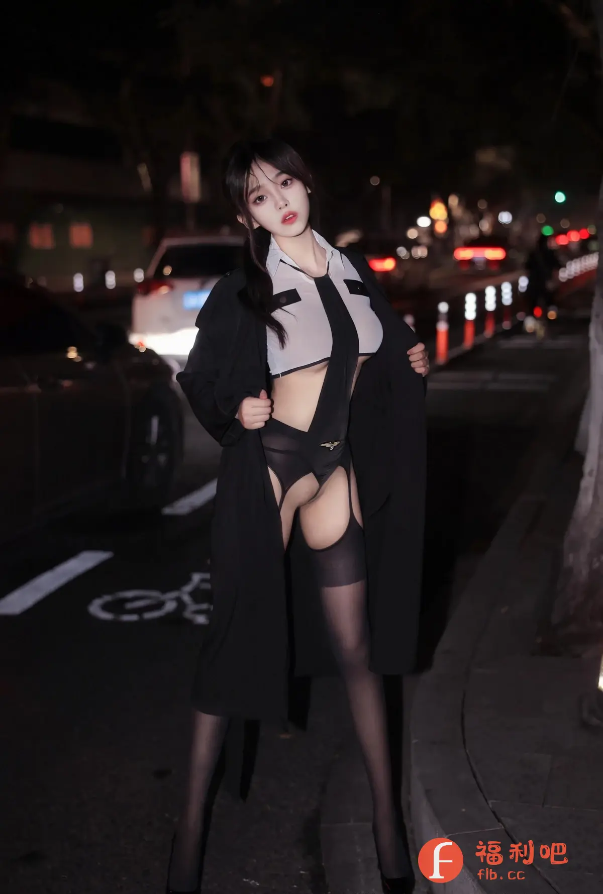 照片中,一位年轻漂亮的亚洲女性站在夜晚的街头。她穿着一件类似空乘制服的性感服装,包括一件敞开的白色衬衫和黑色领带,搭配黑色的内衣和吊带袜。她还穿着一件黑色的长款外套,外套敞开,展示着她的性感装扮。背景是夜晚的街道,有车辆驶过,路灯闪烁。整体氛围性感而神秘,光线昏暗,突出了人物的魅力。