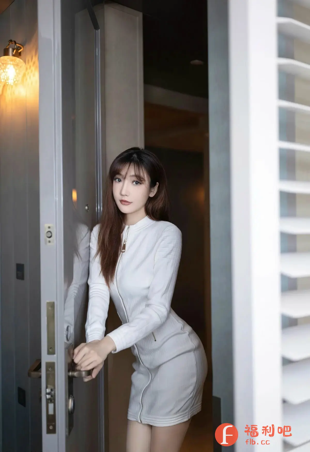画面中一位年轻漂亮的亚洲女性,她站在一扇打开的门旁边,对着镜头摆出优雅的姿势。她拥有一头柔顺的长发,刘海自然地垂在额前,衬托出精致的五官和清澈明亮的眼睛。她穿着一件时尚的白色连衣裙,连衣裙采用拉链设计,凸显了她优美的身姿。她一手扶着门把手,姿态自然大方。背景是现代简约的室内环境,柔和的光线洒在她的身上,营造出一种温馨而私密的气氛。整体画面构图精美,色彩和谐,展现了女性的魅力和时尚感。