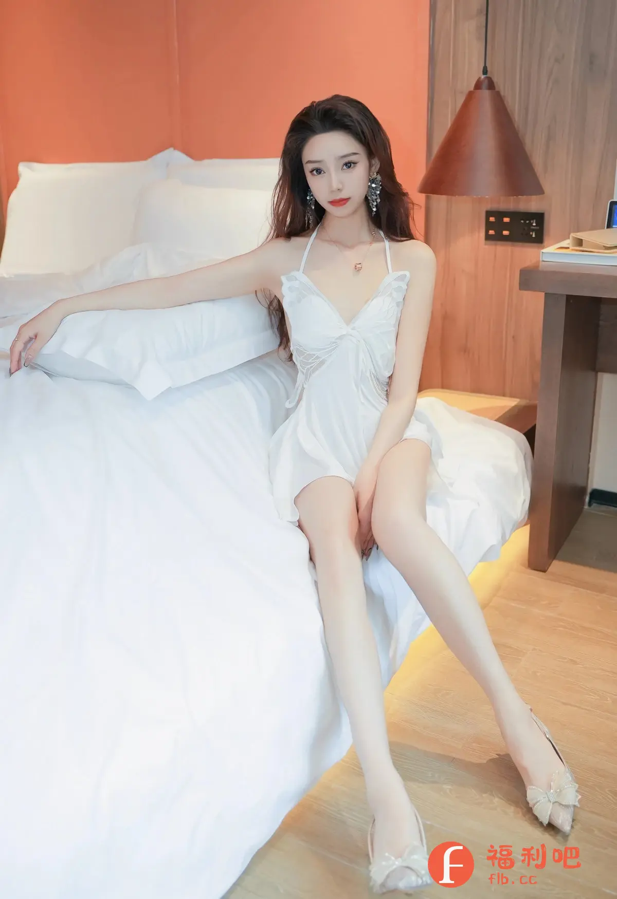 描述:这位年轻女子身穿白色蕾丝吊带睡裙,优雅地坐在柔软的白色床铺上。她的长发微卷,佩戴着精致的耳环和项链,精致的妆容凸显出她迷人的气质。她的一只手轻轻搭在枕头上,另一只手自然地放在腿上,显得relaxed又性感。房间背景柔和,床头灯散发着温暖的光芒,营造出一种温馨舒适的氛围。她脚上穿着一双带有蝴蝶结装饰的浅色高跟鞋,更显优雅。整体照片风格清新,展现了女性柔美的一面。