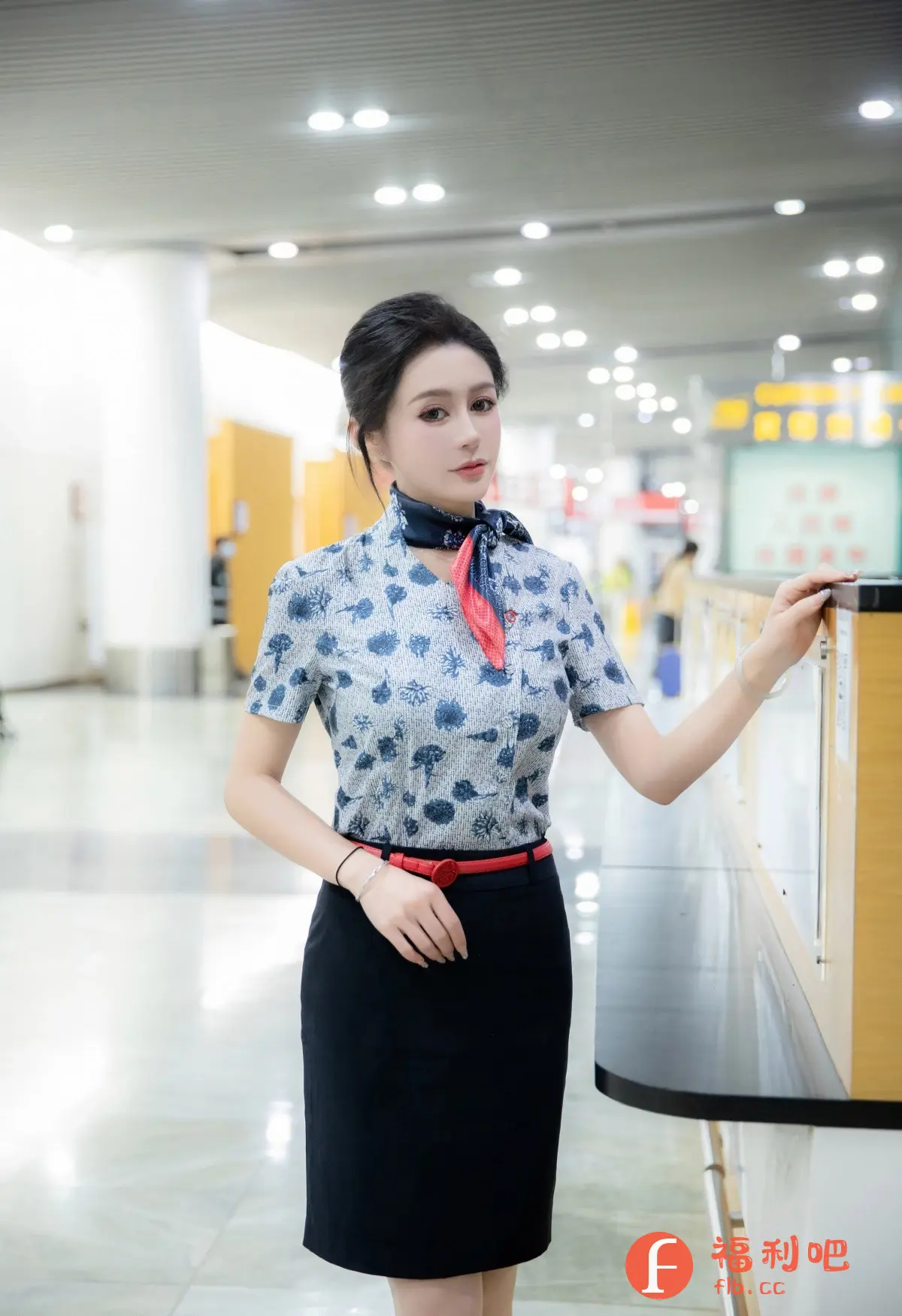 描述:照片中是一位穿着制服的亚洲女性,她优雅地站在一个类似于机场或酒店的接待区域。她身穿一件印有蓝色花纹的短袖衬衫,脖子上系着一条红蓝相间的丝巾,腰间系着一条红色腰带,下身是一条黑色包臀裙,整体装扮简洁干练。她的头发整齐地盘起,妆容精致,显得很有气质。
背景是一个宽敞明亮的公共区域,可以看到柱子、指示牌和一些其他的工作人员或旅客。整体的色调是明亮而柔和的,营造出一种专业而舒适的氛围。她的手轻轻搭在一个木质台面上,眼神柔和地看向前方,给人一种亲切而专业的感觉。这张照片很可能是一位空乘人员或酒店工作人员的形象照。
返回格式必须为识别内容
描述:一位身穿制服的亚洲女性站在机场或酒店接待区域,服装包括印花衬衫、丝巾、红色腰带和黑色包臀裙,背景是明亮公共区域。
