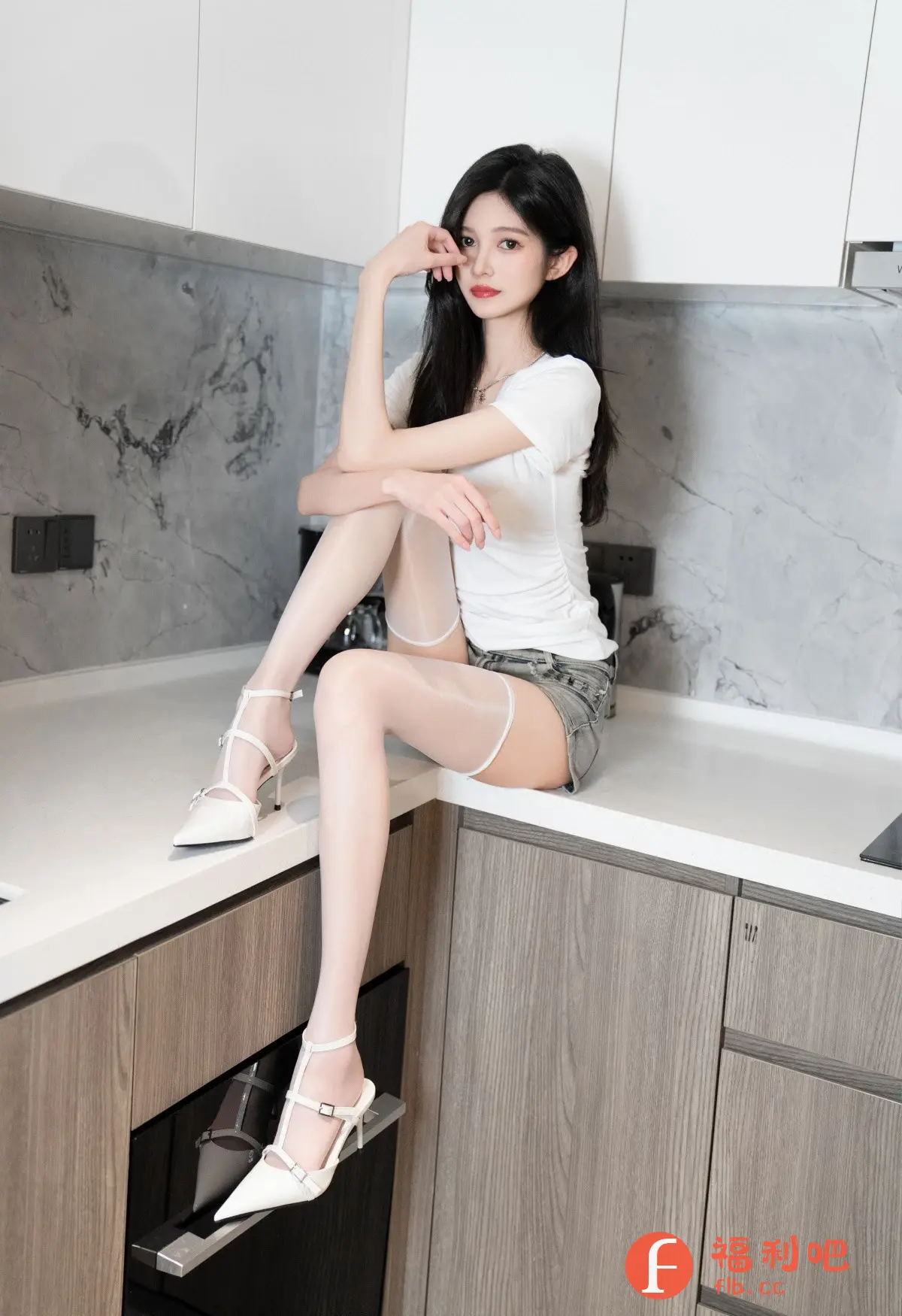 描述:照片中,一位年轻女子坐在现代厨房的台面上。她穿着一件简单的白色T恤和牛仔短裤,搭配一双白色的及膝丝袜和高跟鞋,展现了性感和休闲的混合风格。她拥有一头乌黑的长发,红唇艳丽,一只手轻轻托着下巴,姿态优雅。厨房背景简约时尚,灰色大理石纹路的墙面与浅色调的橱柜形成对比。整体构图展现了现代都市女性的自信与美丽。