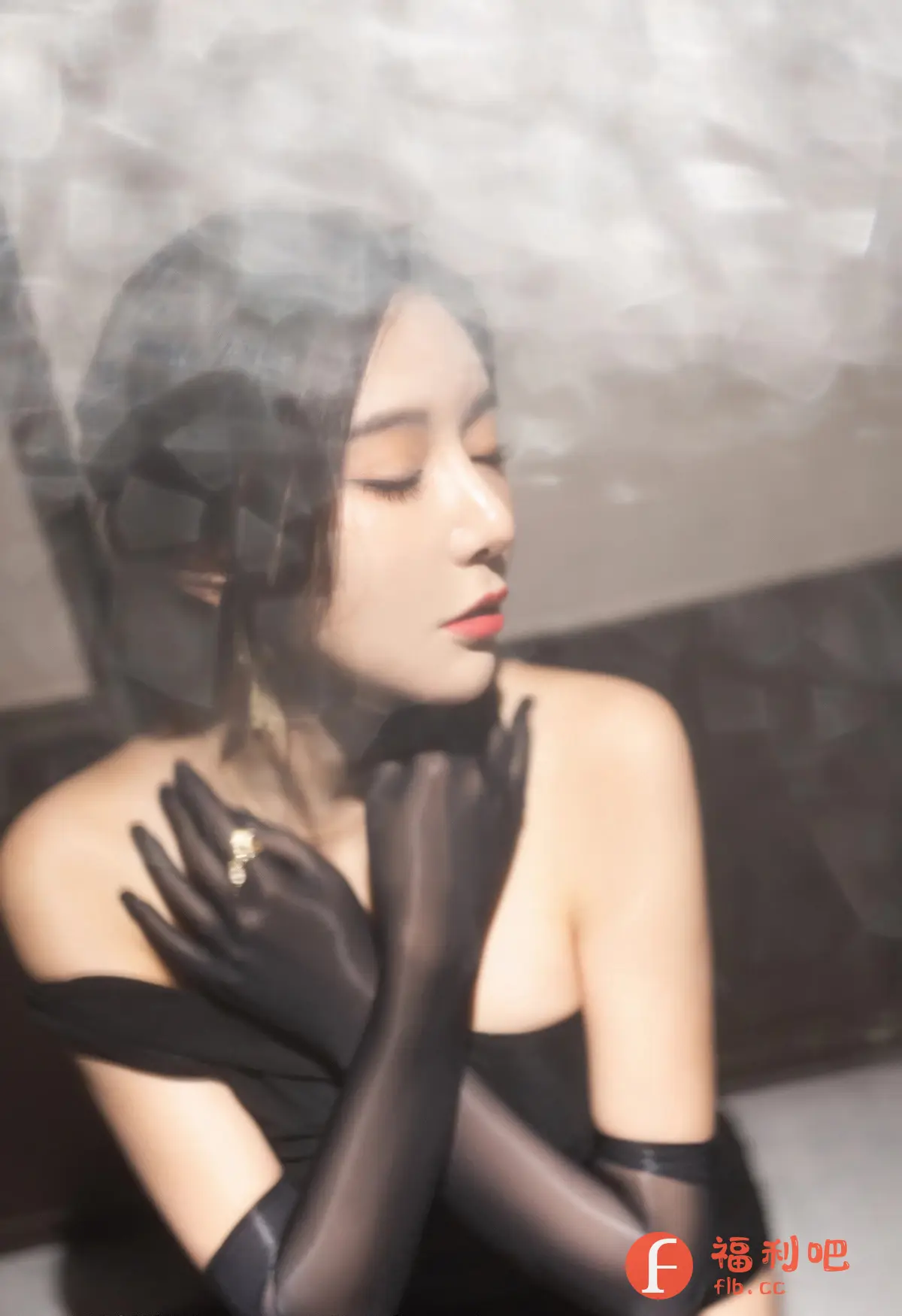 描述:照片中是一位美丽的亚洲女性,她闭着眼睛,面容精致,轮廓分明,展现出一种静谧和优雅。她身穿一件黑色的露肩礼服,搭配一双同样是黑色的长款丝质手套,手套上还佩戴着一枚闪亮的戒指,增添了一丝奢华感。她的头发乌黑亮丽,造型简洁大方,更突显了她颈部的优美线条。整体光线柔和,背景模糊,营造出一种朦胧的美感,仿佛置身于梦幻之中。照片的构图和色彩搭配都非常和谐,展现了摄影师高超的拍摄技巧和艺术品味。