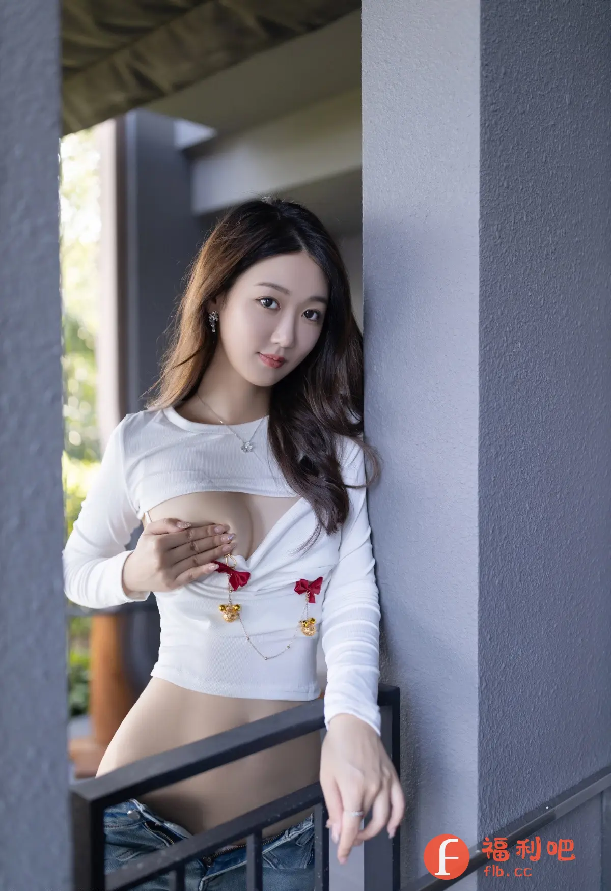 描述:照片中,一位年轻美丽的亚洲女性身穿白色长袖露脐上衣,下搭牛仔短裤,站在一个类似阳台或走廊的地方。她靠在一个灰色的柱子上,一只手遮住胸前,另一只手则搭在黑色的栏杆上。她的长发披肩,化着精致的妆容,佩戴着耳环和项链,眼神温柔地注视着镜头,显得妩媚动人。整体光线柔和,营造出一种私密而放松的氛围,可以判断是私房写真的风格。
