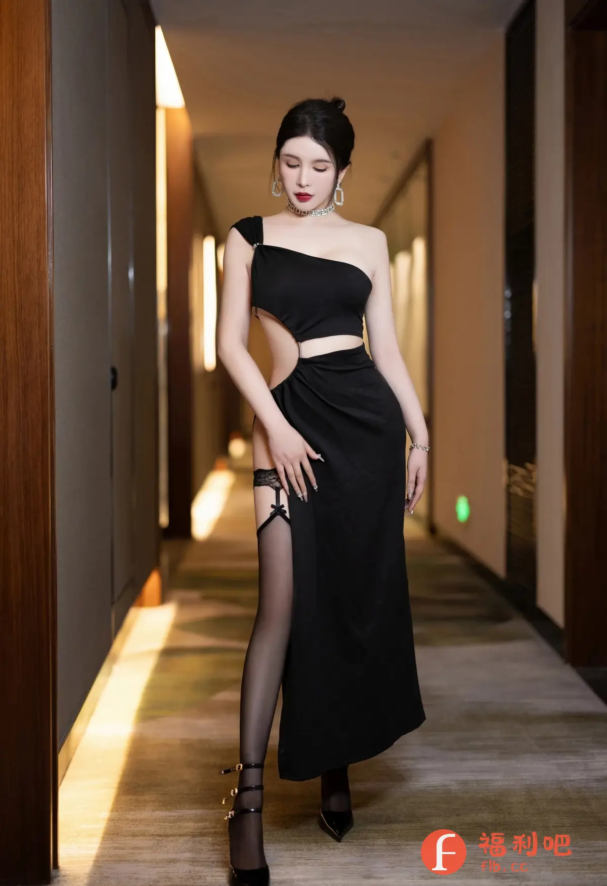 照片中一位穿着黑色单肩开叉长裙的美女站在走廊里。她皮肤白皙,身材苗条,连衣裙设计独特,一侧露出腰部和腿部线条,搭配黑色丝袜和高跟鞋,显得性感而优雅。美女佩戴着精致的项链和耳环,头发盘起,妆容精致,眼神略带忧郁,增添了一丝神秘感。走廊光线柔和,背景简洁,更加突出了美女的美丽和气质。