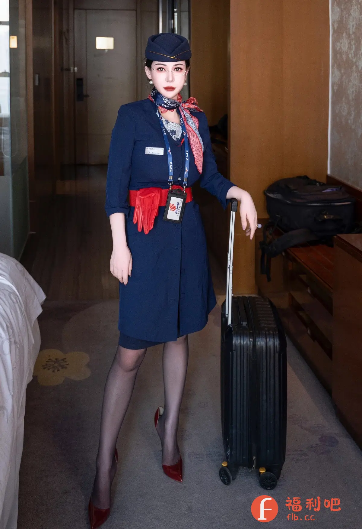 照片中,一位身着经典空乘制服的年轻女性优雅地站在室内,准备出行。她头戴深蓝色制服帽,颈间系着一条精致的印花丝巾,制服腰间束着一条鲜艳的红色腰带,手套也别在腰间。她身着深蓝色连衣裙制服,搭配黑色丝袜和一双红色高跟鞋,显得干练而充满魅力。她的妆容精致,红唇与红色配饰相呼应,更增添了女性的柔美。她一只手扶着一个黑色拉杆箱,似乎正准备开始一段旅程。背景是酒店房间的内部,可以看出房间的装修风格简约而现代。整个画面充满了旅行的氛围,以及空乘人员的专业与优雅。