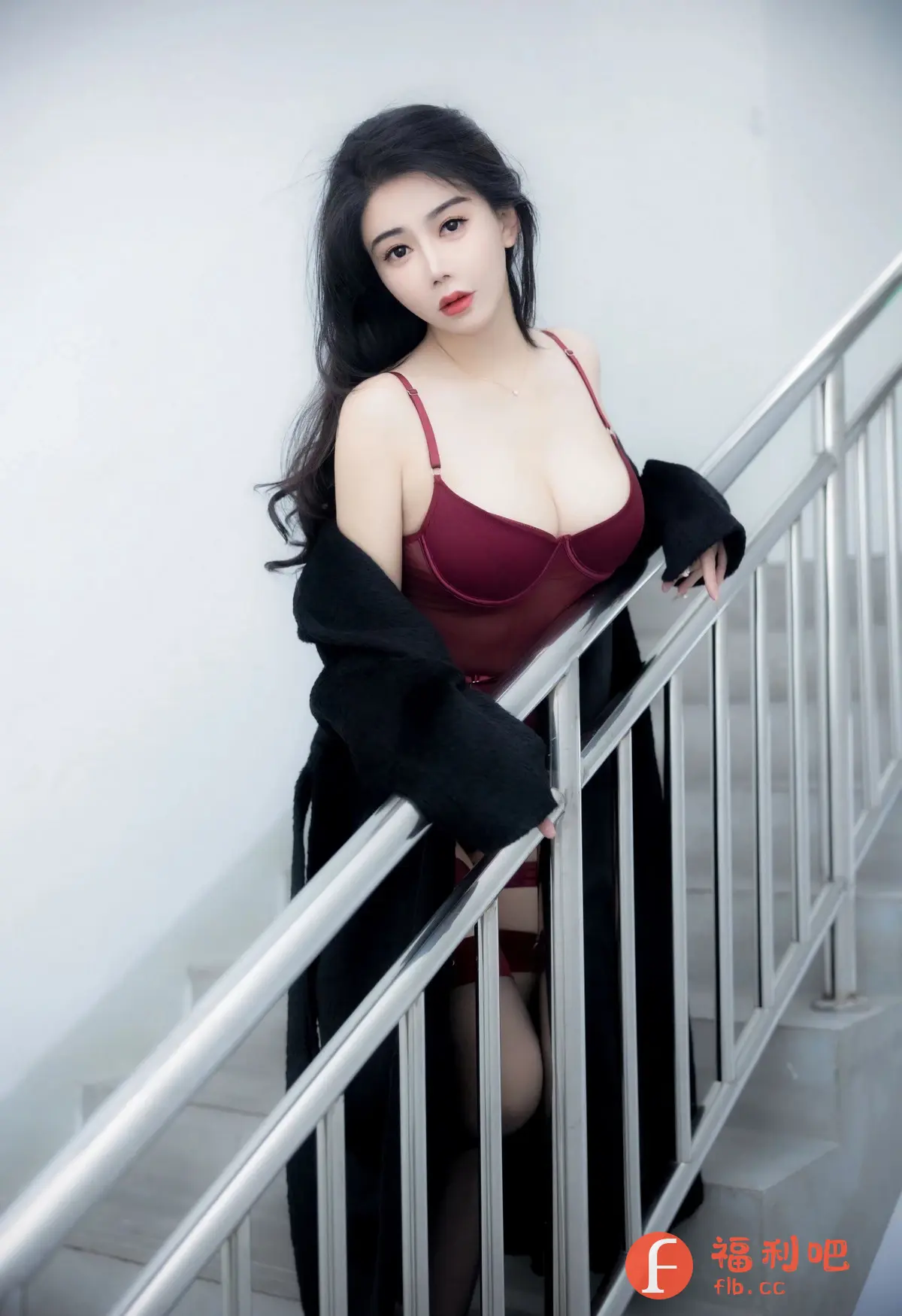 描述：照片中是一位身材姣好、容貌精致的亚洲女性，她站在楼梯上，姿态妩媚动人。她身穿一件深红色蕾丝内衣，搭配黑色长款开衫，更显性感迷人。乌黑的长发自然披散在肩头，衬托出她白皙的皮肤。她的眼神充满魅力，仿佛能洞察人心。背景是简洁的白色墙面和银色楼梯扶手，突出了人物的美丽。整体光线柔和，营造出一种私密、慵懒的氛围，展现了女性的柔美和自信。这是一张极具艺术感的写真作品，充分展现了模特的个人魅力和摄影师的拍摄技巧。

性感写真，亚洲女性，蕾丝内衣，黑色开衫，楼梯，妩媚，迷人