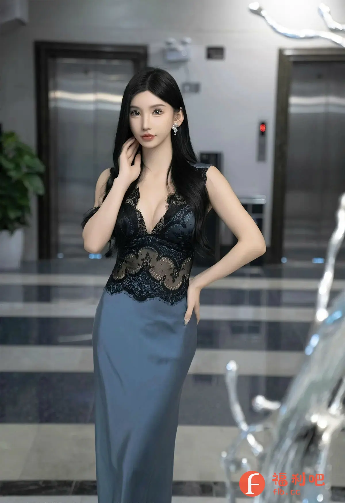 描述：这张照片是一位亚洲美女的私房写真，她身穿一件精致的黑色蕾丝上衣和丝绸质地的蓝色长裙。上衣的蕾丝设计性感而优雅，隐约透露出肌肤，长裙则凸显了她修长的身材曲线。她右手轻抚脖颈，左手叉腰，姿态妩媚动人。她拥有乌黑亮丽的披肩长发，白皙的皮肤和精致的五官，眼神中透露出一种神秘的气息。背景是现代化的室内环境，带有金属质感的电梯门和艺术装饰品，增加了照片的时尚感和高级感。整体光线柔和，营造出一种温馨浪漫的氛围，展现了女性的魅力和自信。

识别内容：一位亚洲美女的私房写真，身穿蕾丝上衣和丝绸长裙，背景是现代化的室内环境。