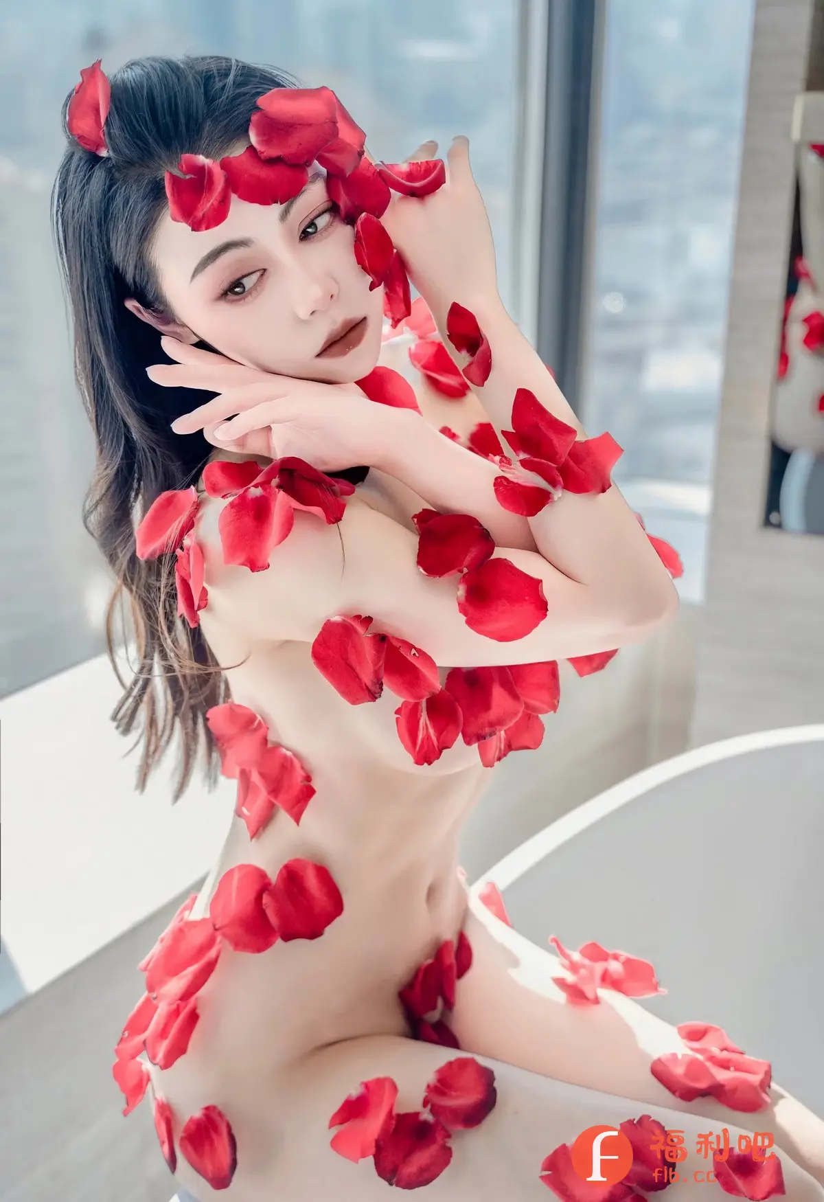 描述：照片中，一位年轻女性坐在浴缸边，她的身体被红色的玫瑰花瓣覆盖，营造出一种浪漫而神秘的氛围。她拥有一头乌黑亮丽的长发，精致的妆容凸显出她妩媚动人的气质。她用双手轻轻地扶着脸庞，眼神迷离，充满了诱惑力。背景中可以看到明亮的窗户和浴缸的边缘，进一步增强了画面的美感和意境。整体来看，这张照片展现了女性的柔美和性感，同时又带有艺术感，引人遐想。