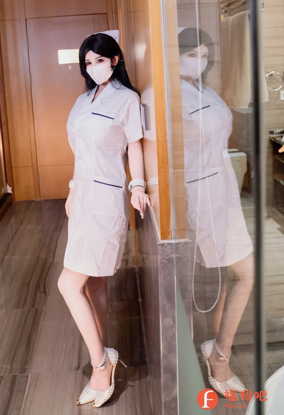 照片中是一位穿着护士制服的美女。她戴着口罩,黑色的长发披散在肩上,头上戴着护士帽。她身穿白色短袖制服,制服边缘有蓝色滚边,下摆长度在膝盖以上。她倚靠在墙边,姿态优雅。脚上穿着一双带有金色鞋头的白色高跟鞋,更显时尚。照片背景看起来像是一个酒店房间或者公寓,整体风格私密且具有吸引力。
