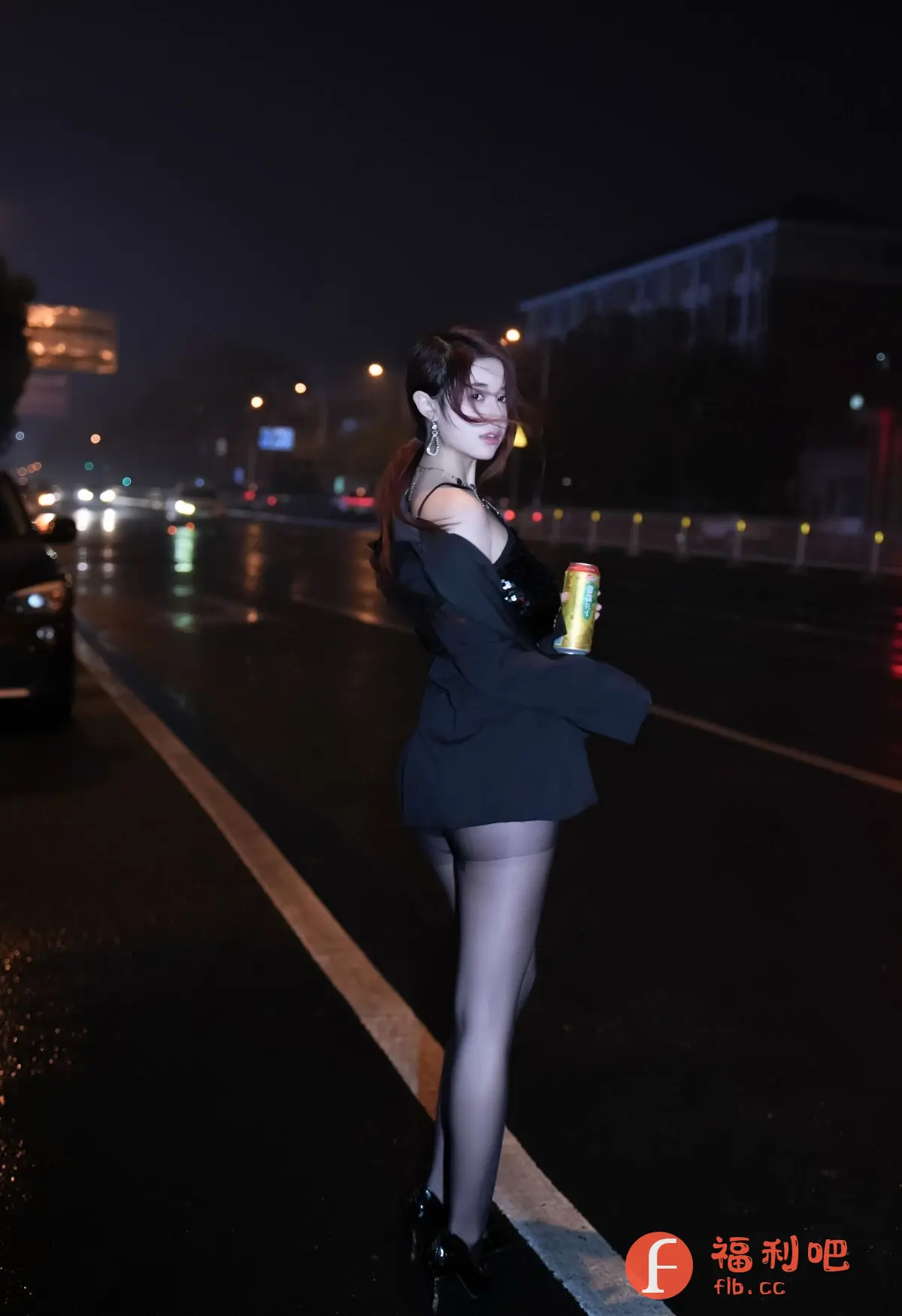 这张照片是一位年轻女子在夜晚的街头拍摄的。她穿着一件黑色亮片上衣,外面披着一件黑色外套,下身穿着黑色丝袜和高跟鞋。她手里拿着一罐饮料,可能正在享受一个轻松的夜晚。背景是湿漉漉的街道和模糊的城市灯光,营造出一种浪漫而又神秘的氛围。女子的发型和妆容都很精致,让她看起来更加迷人。整体而言,这张照片捕捉到了女子在夜晚街头的独特魅力,展现了她的自信和时尚感。