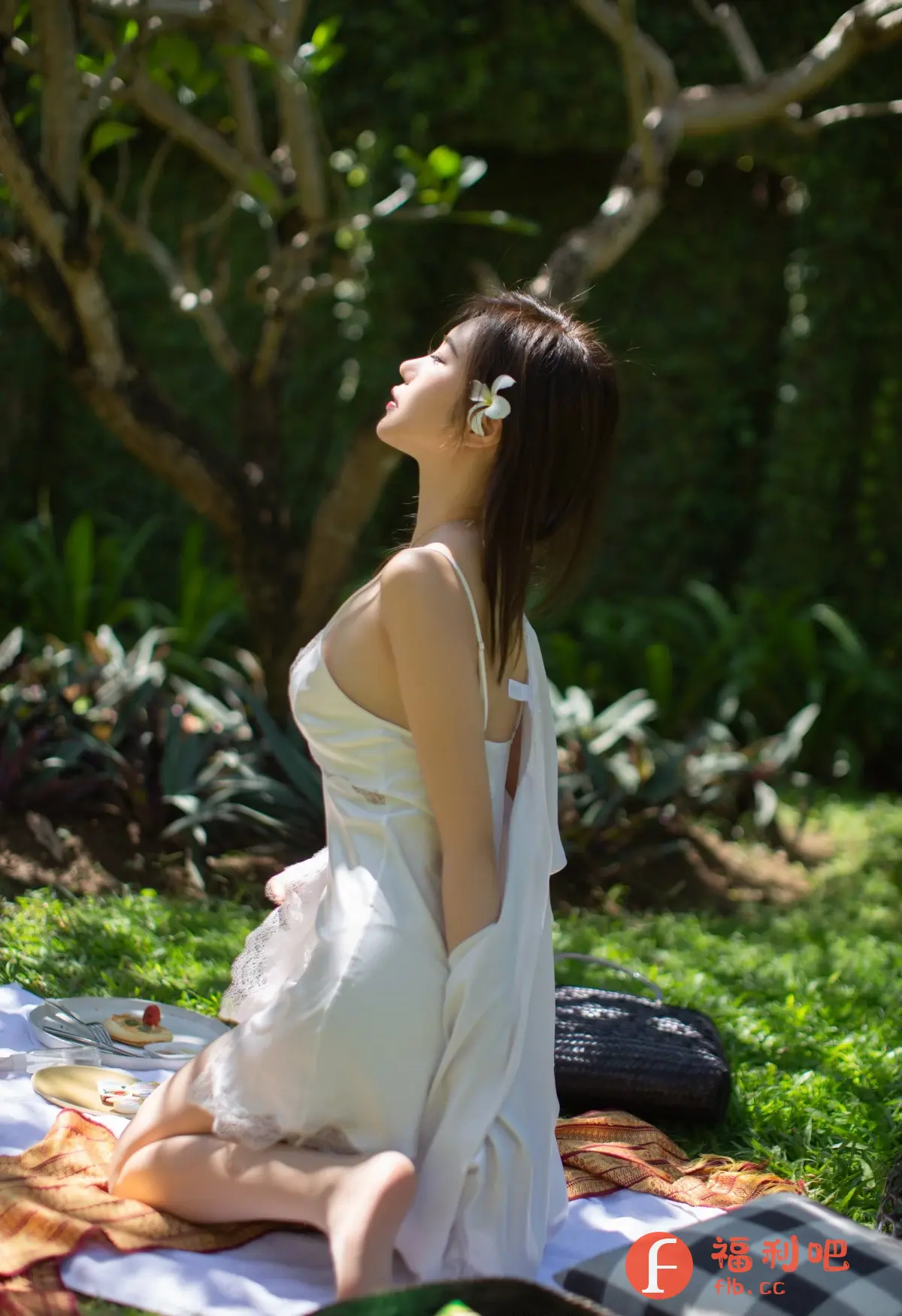 照片中,一位年轻女子跪在绿草如茵的草地上,享受着阳光。她身穿一件白色丝绸睡衣,搭配一件宽松的白色外套,显得清新而性感。她的头发柔顺地披在肩上,一朵白色的小花别在耳边,增添了几分浪漫气息。她仰着头,闭着眼睛,似乎在感受阳光的温暖和微风的轻拂。
她的周围摆放着野餐垫、餐具、食物和靠垫,营造出一种悠闲自在的氛围。照片的光线柔和,色彩鲜明,突出了女子的美丽和环境的优美。整体画面充满了青春活力和浪漫情调,给人一种舒适愉悦的感觉。这似乎是她在私密的空间里,展现自己美丽与个性的写真照片,充满了生活气息和艺术感。