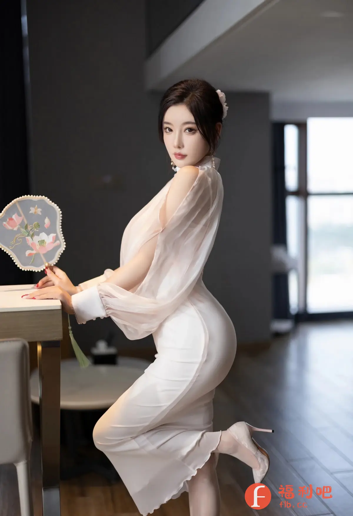 这位美女身穿一件白色连衣裙，气质优雅，身材曲线玲珑有致。裙子的设计别具一格，薄纱的袖子增添了飘逸感，恰到好处地展现了她的肩部线条。她一手扶着桌子，另一只手拿着一把带有花朵图案的扇子，更显古典韵味。她的头发盘起，配以精致的头饰，妆容精致，眼神迷人。整个画面充满了东方女性的柔美和韵味，凸显了她的高贵气质和迷人魅力。她站在室内，背景是简约现代的装修风格，与她的古典气质形成了鲜明的对比，更衬托出她的独特魅力。