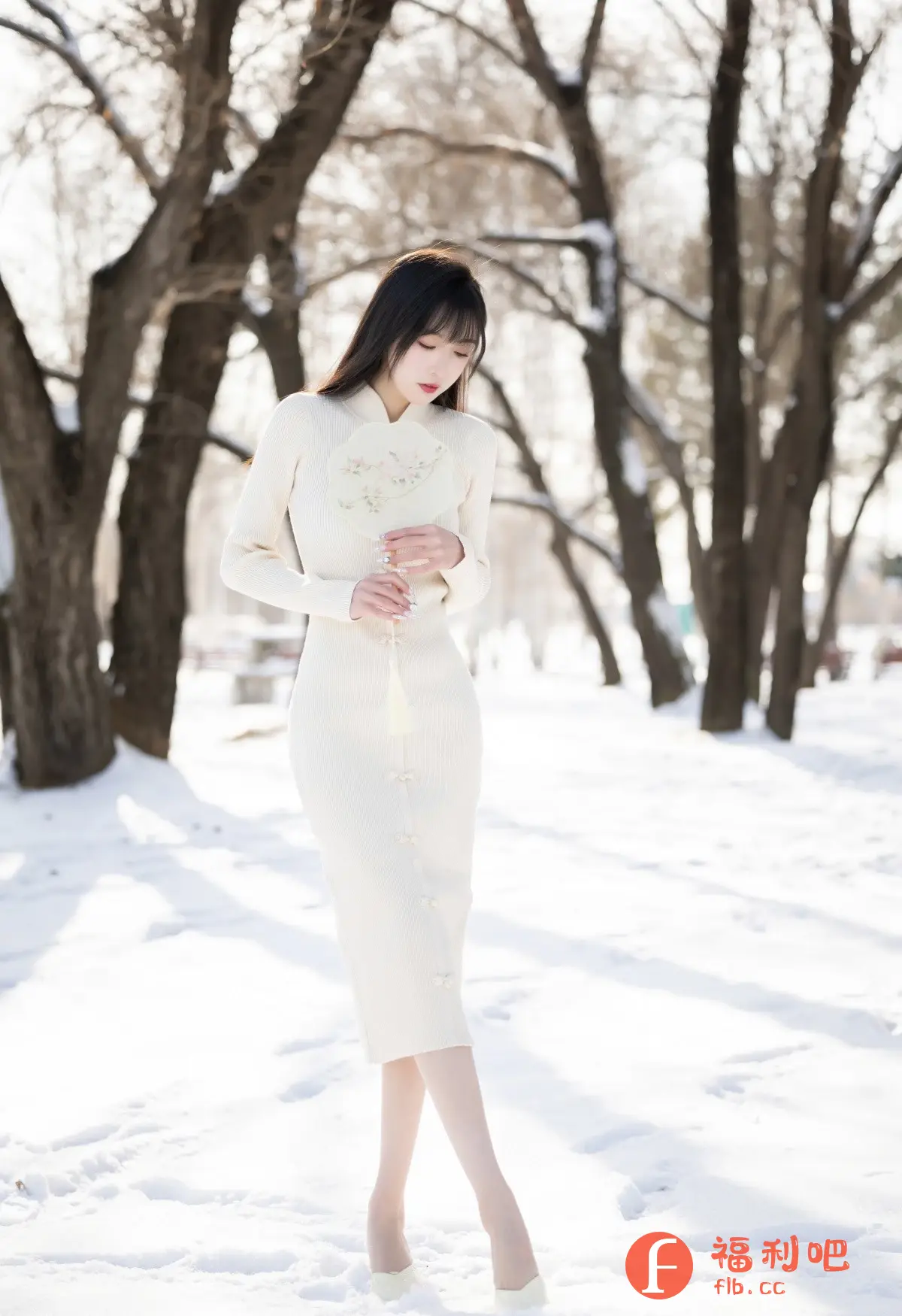 这位年轻女性站在一片覆盖着白雪的土地上,周围环绕着光秃秃的树木。她身穿一件优雅的奶油色长袖旗袍式连衣裙,搭配同色系的鞋子。连衣裙的设计简约而修身,带有精致的盘扣细节,凸显了她的身材。她手持一把带有精美花卉图案的圆形扇子,更增添了几分古典韵味。她的长发乌黑柔顺,自然垂落,衬托出她清秀的面容。她的眼神略带忧郁,似乎沉浸在自己的思绪中。整体画面充满了东方美学的意境,优雅而宁静,展现出一种独特的东方女性魅力。