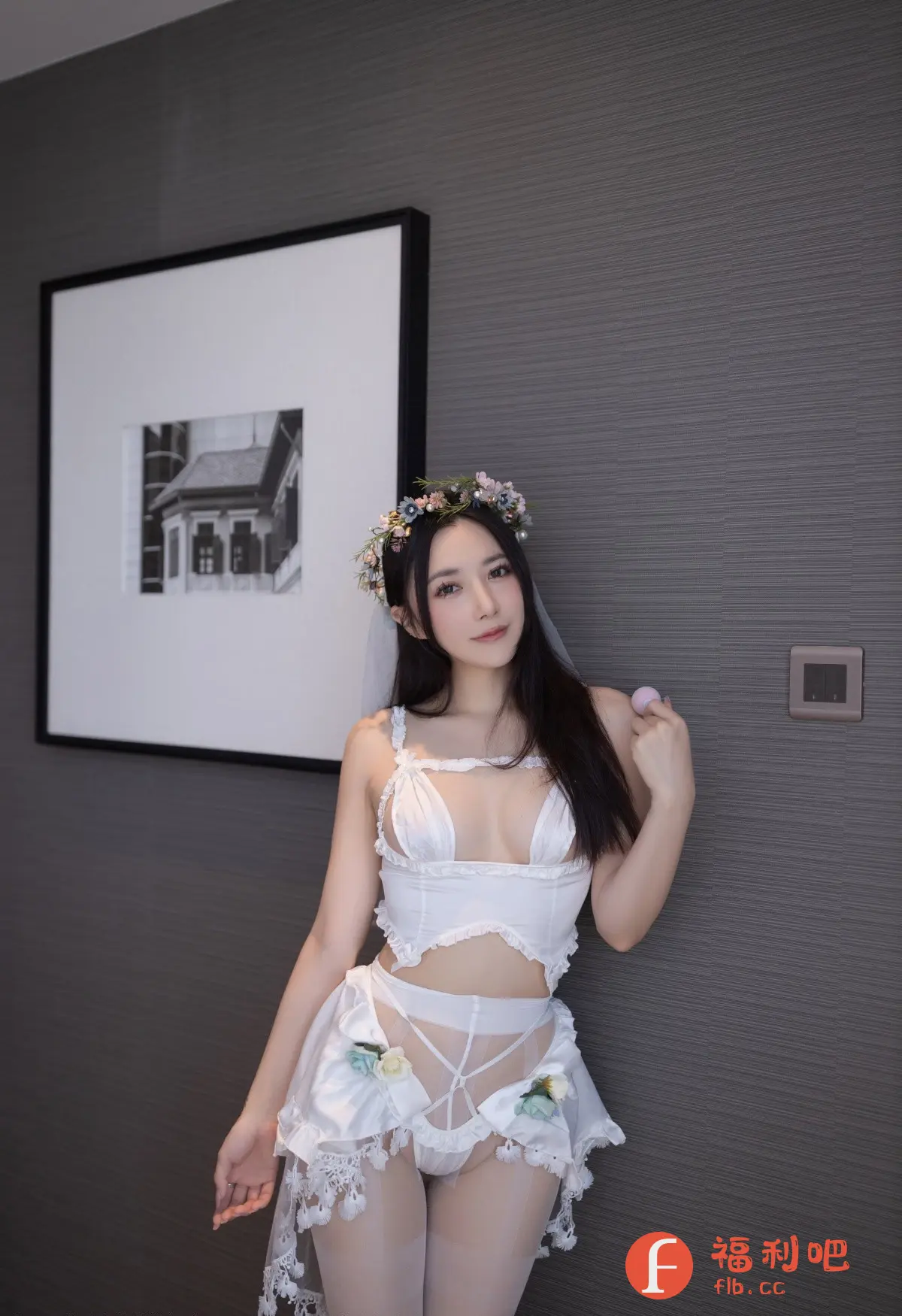 描述:这张照片展现了一位年轻女性身着精致的白色内衣,内衣设计颇具创意,上半身是带有镂空设计的吊带上衣,下半身搭配一条带有花朵装饰的短裙,整体风格性感又不失清新。她的头上戴着一顶鲜花花环,头纱轻柔地垂下,增添了几分梦幻感。她倚靠在灰色的墙壁上,墙上挂着一幅黑白照片,背景简洁,凸显了人物的美丽。她的姿态优雅,眼神温柔,整体画面充满了浪漫和私密的氛围。照片的构图和光线运用恰到好处,展现了女性的柔美曲线和迷人魅力。
一位身着白色内衣的年轻女性,头戴鲜花花环,倚靠在灰色的墙壁上。