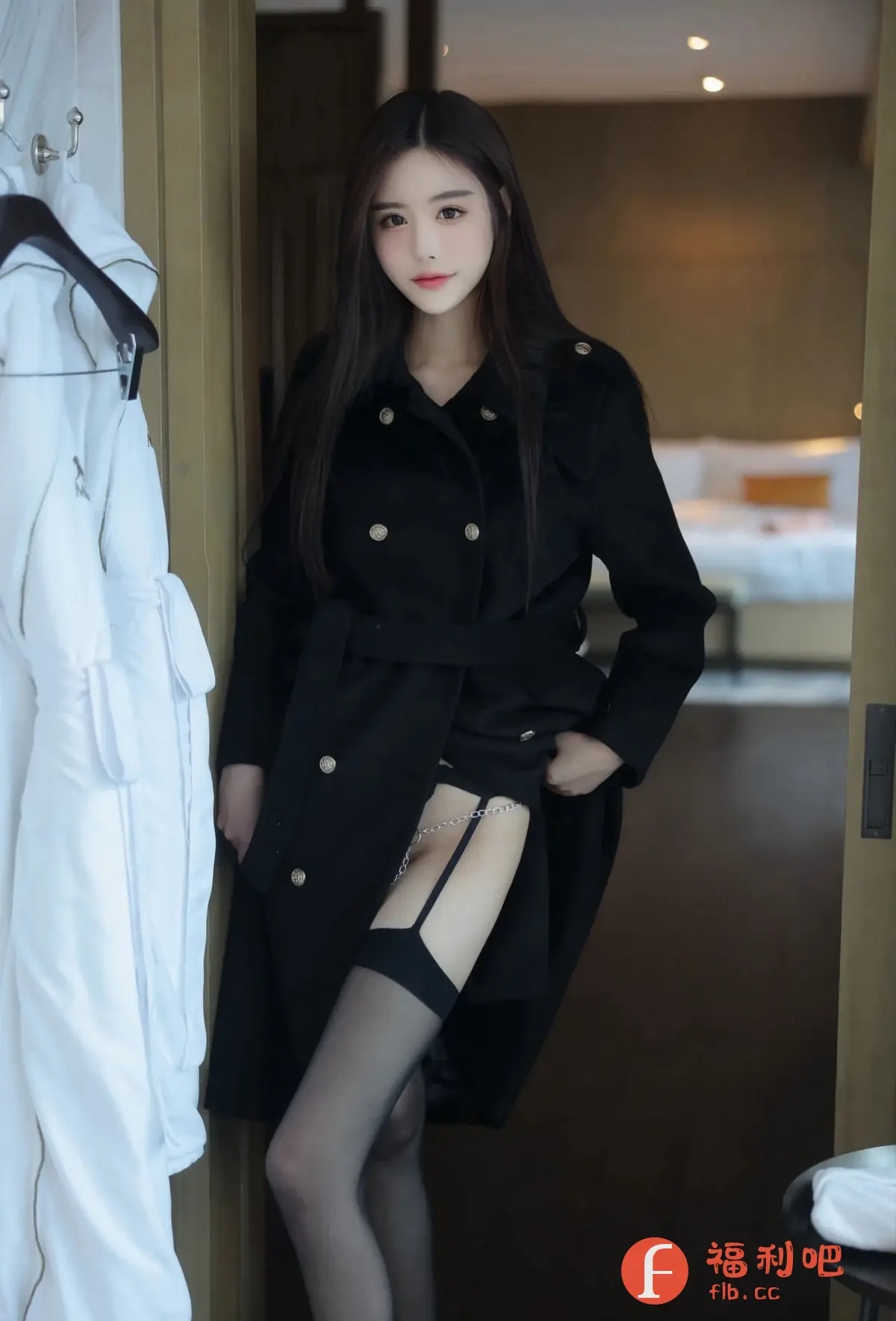 这张照片是一位年轻女性的性感私房写真。她穿着一件黑色双排扣风衣,腰间系着带子,风衣敞开,露出穿着黑色丝袜和吊袜带的腿。吊袜带上装饰着一条银色链子,增添了一丝性感和挑逗。她身材苗条,皮肤白皙,长长的黑发披在肩上。她站在一个房间的门口,背景模糊,可以看到房间里的床。整体氛围诱人且神秘。她的眼神充满魅力,吸引着观众的视线。左边挂着一件白色的浴袍,更增添了居家和私密的氛围。整张照片的构图和光线都恰到好处,突出了女性的美丽和性感。