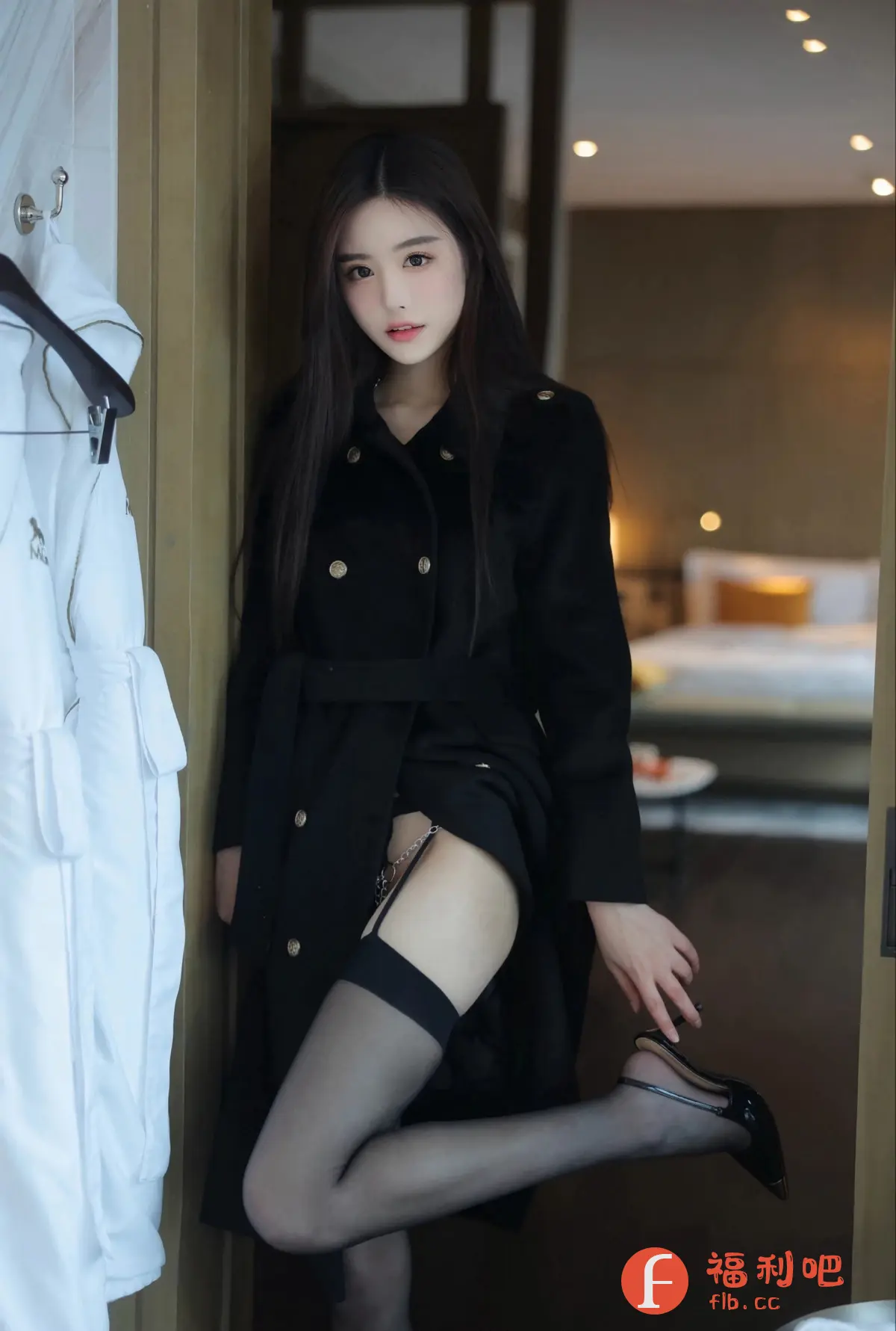 这是一张颇具诱惑力的美女私房写真照片。画面中,一位年轻貌美的亚洲女性站在门边,身穿一件系腰带的黑色双排扣风衣,风衣下隐约可见黑色性感内衣和吊袜带,透露着神秘和妩媚。她穿着一双黑色的丝袜和高跟鞋,将修长的双腿展现得淋漓尽致。她用手扶着高跟鞋,姿态撩人。背景是布置温馨的房间,床头灯散发着柔和的光芒。整体构图和光线都营造出一种私密、暧昧的氛围,让人不禁浮想联翩。照片的风格性感而大胆,展现了女性的魅力和自信。