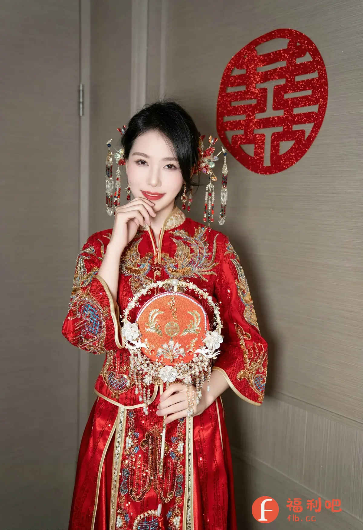 照片中,一位年轻的亚洲女性身穿传统的中国红色结婚礼服,显得雍容华贵。她的头发精心盘起,装饰着华丽的头饰,垂坠的珠帘更增添了几分妩媚。她手持一把精致的团扇,上面绣有吉祥的图案,与礼服上的刺绣相呼应。她面带微笑,一手托腮,眼神温柔而充满喜悦。背景墙上装饰着一个红色的双喜字,象征着新婚的喜庆和美好。整体画面色彩鲜艳,细节丰富,展现了传统中式婚礼的庄重和浪漫,以及新娘幸福美好的状态。
一位穿着红色中式结婚礼服的年轻女性,手持团扇,背景墙上装饰着红色双喜字。