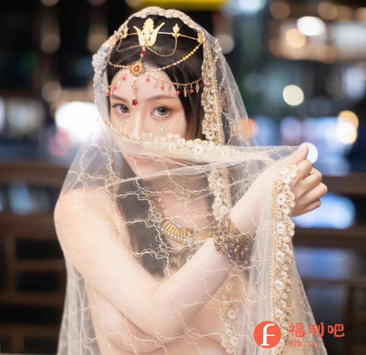 这是一张极具异域风情的女性私房写真。照片中的女子身着精致的传统服饰,头上戴着华丽的头饰,额头和眼角处点缀着亮片,更显神秘和妩媚。她的面部被薄纱遮掩,露出迷人的眼睛,眼神深邃而充满吸引力。脖子上戴着设计独特的项链,手腕上也佩戴着精美的配饰,凸显了高贵的气质。薄纱轻柔地遮盖着她的身体,营造出一种朦胧而性感的氛围。背景虚化,突出人物主体,整体画面色彩柔和,光线运用恰到好处,增添了照片的艺术感。这是一张非常具有吸引力的女性写真照片,展现了女性的柔美和神秘。