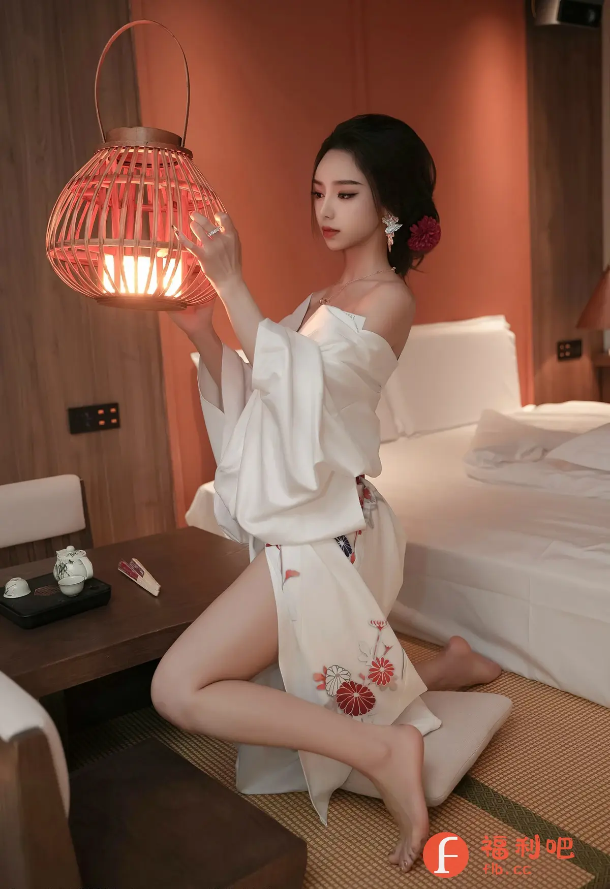 照片中,一位年轻的东方女性跪坐在榻榻米地板上,身穿一件宽松的白色和服,和服上印有精致的红色和白色花朵图案。她的头发盘起,一朵红色的花朵点缀在发髻旁,增添了几分妩媚。她手持一个镂空的竹制灯笼,灯笼散发着柔和的光芒,照亮了她的脸庞,更显肌肤白皙细腻。
她的姿势优雅,眼神专注地凝视着手中的灯笼,仿佛沉浸在自己的世界中。背景是一个简约的房间,摆放着一张铺着白色床单的床和一个木制茶几,上面摆放着茶具,营造出一种宁静而温馨的氛围。整个画面充满了东方韵味,展现了女性的柔美和内敛。