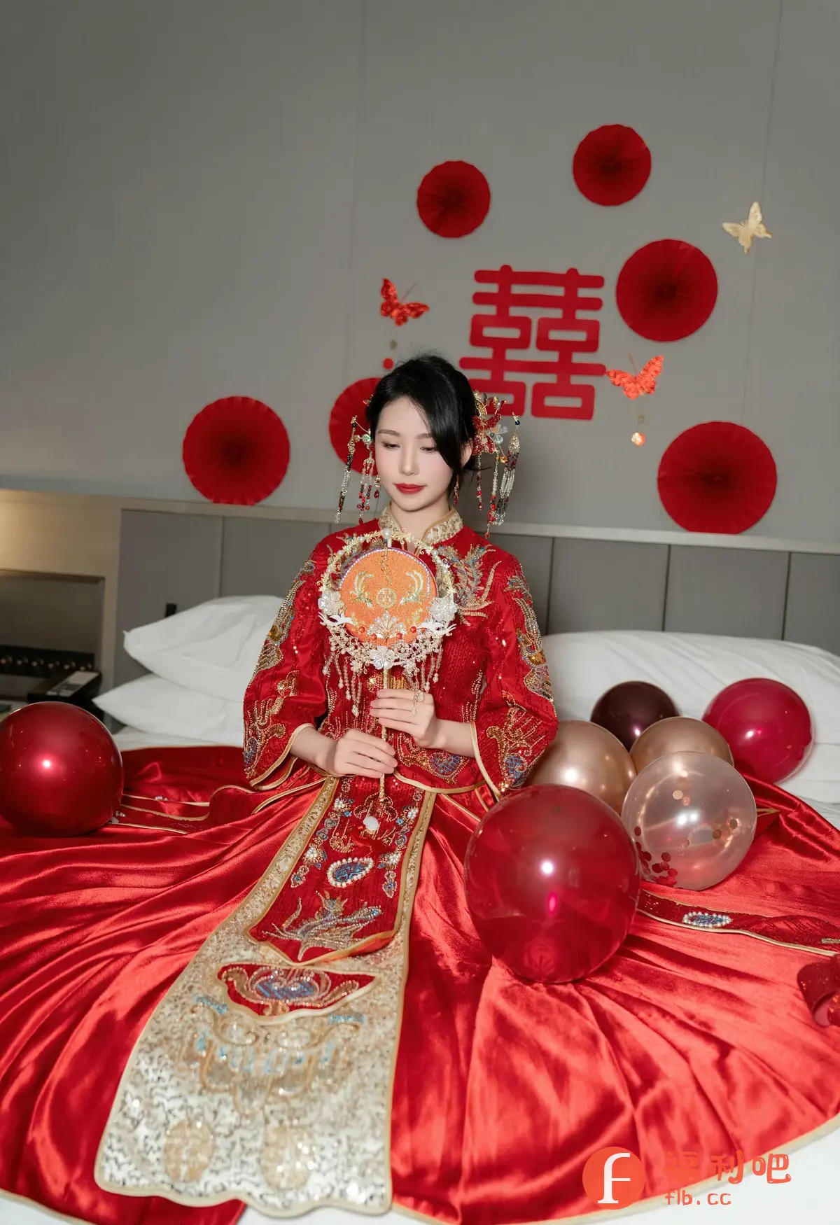 这是一张充满喜庆氛围的女性私房写真。照片中,一位身着传统红色中式嫁衣的年轻女子端庄地坐在铺满红色丝绸的床上,周围环绕着红色和金色的气球。她手持一把精美的团扇,头饰华丽,妆容精致,显得优雅动人。背景墙上装饰着红色的喜字和纸质装饰,进一步烘托出喜庆的氛围,暗示着婚庆主题。整体画面色彩鲜艳,细节丰富,展现了东方女性的美丽和传统婚礼的文化内涵。
该照片适合用于婚庆、摄影、时尚等相关主题的宣传或分享。