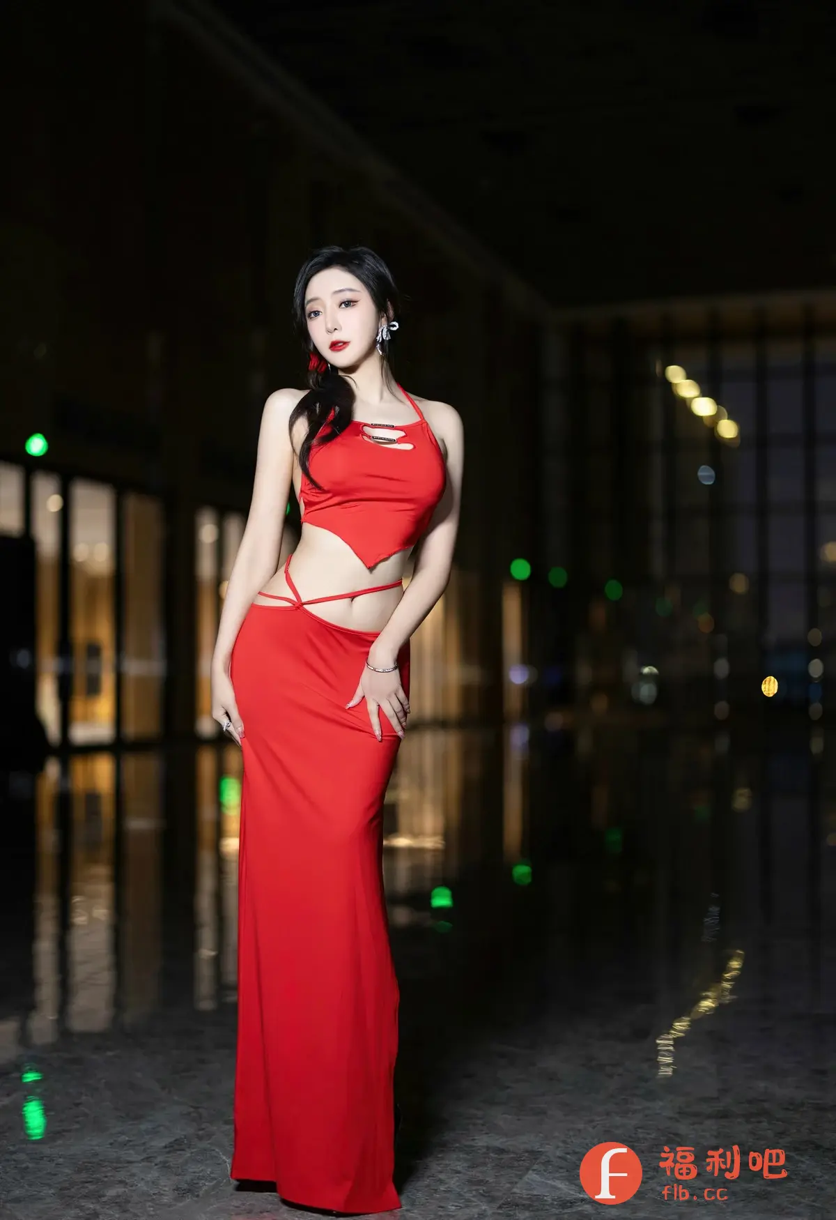 这张照片是一位美丽的亚洲女性在室内拍摄的私房写真。她穿着一身鲜艳的红色露腰长裙，裙子的设计非常独特，展现了她纤细的腰部和修长的身材。她的皮肤白皙，化着精致的妆容，红色的唇膏与裙子的颜色相呼应，更显妩媚动人。背景虚化，营造出一种朦胧的美感，让人们的视线更加集中在她的身上。整体构图和光线运用都非常专业，突出了她的美丽和性感，这是一张充满艺术感的写真作品。