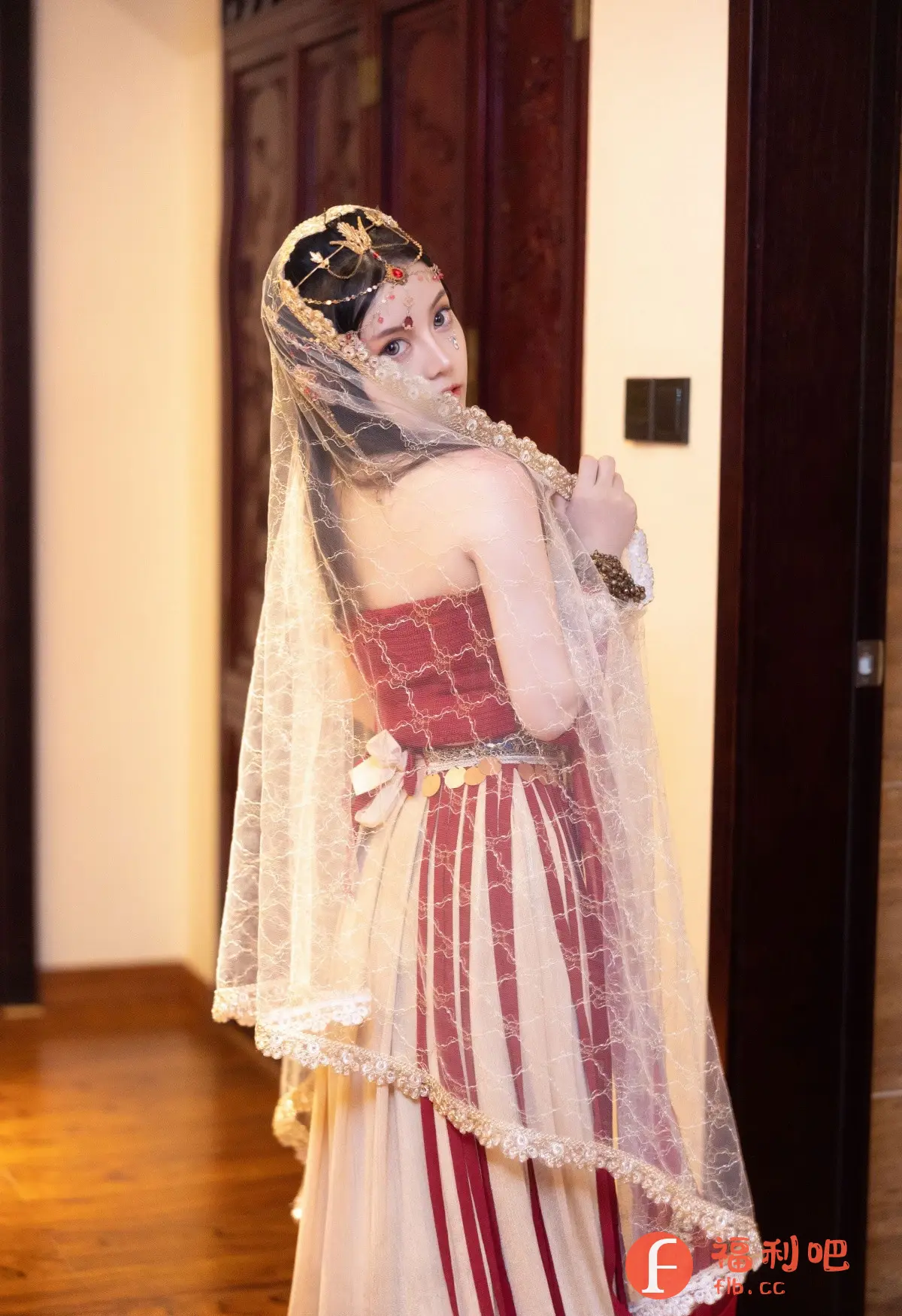 这位美女身着华丽的印度风格服装,站在室内环境中,回眸一笑,展现出迷人的魅力。她头戴精致的头饰,饰有红色宝石和金色的细节,衬托出她娇美的容颜。薄纱遮面,更显神秘。身穿红色和米色的传统服饰,上面有细致的刺绣和装饰。腰间系着一圈金币,增添了奢华感。整体造型充满异域风情,让人感受到浓厚的文化氛围。从拍摄角度来看,照片可能是在一间典雅的房间里拍摄的,背景中可以看到木质的门和墙壁,营造出一种古典而私密的感觉。
美女穿着印度风格的服装,头戴头饰,薄纱遮面,站在室内环境中。