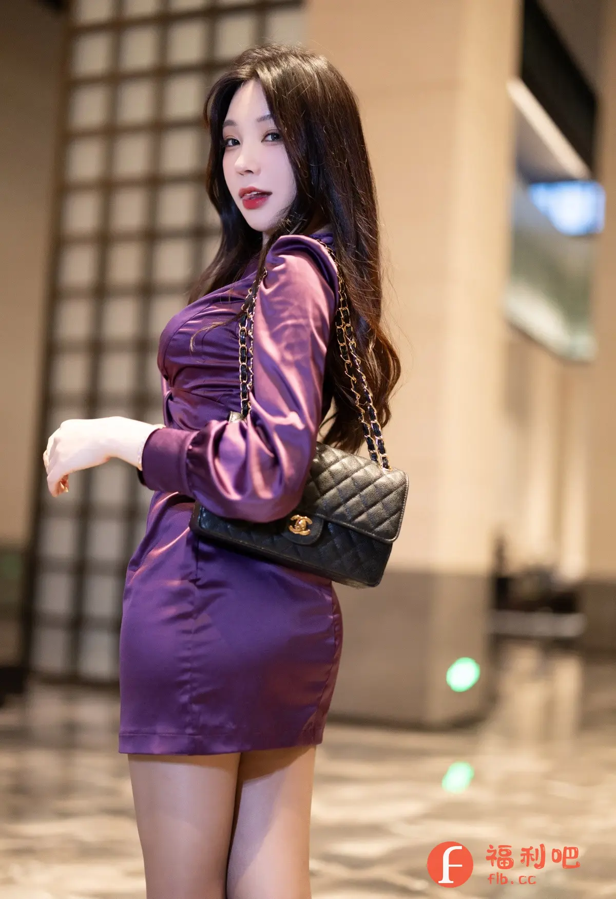 一位年轻的亚洲女性,身材苗条,穿着一件紫色的紧身连衣裙,显得非常性感。她有一头乌黑亮丽的披肩长发,妆容精致,红唇醒目,更增添了她的妩媚。她斜挎着一个黑色的菱格纹包包,链条设计增添了时尚感。背景是室内环境,光线柔和,营造出一种私密而温馨的氛围。她的眼神略带挑逗,姿态优雅,散发出一种自信和迷人的魅力,这是一张非常吸引人的写真照片。