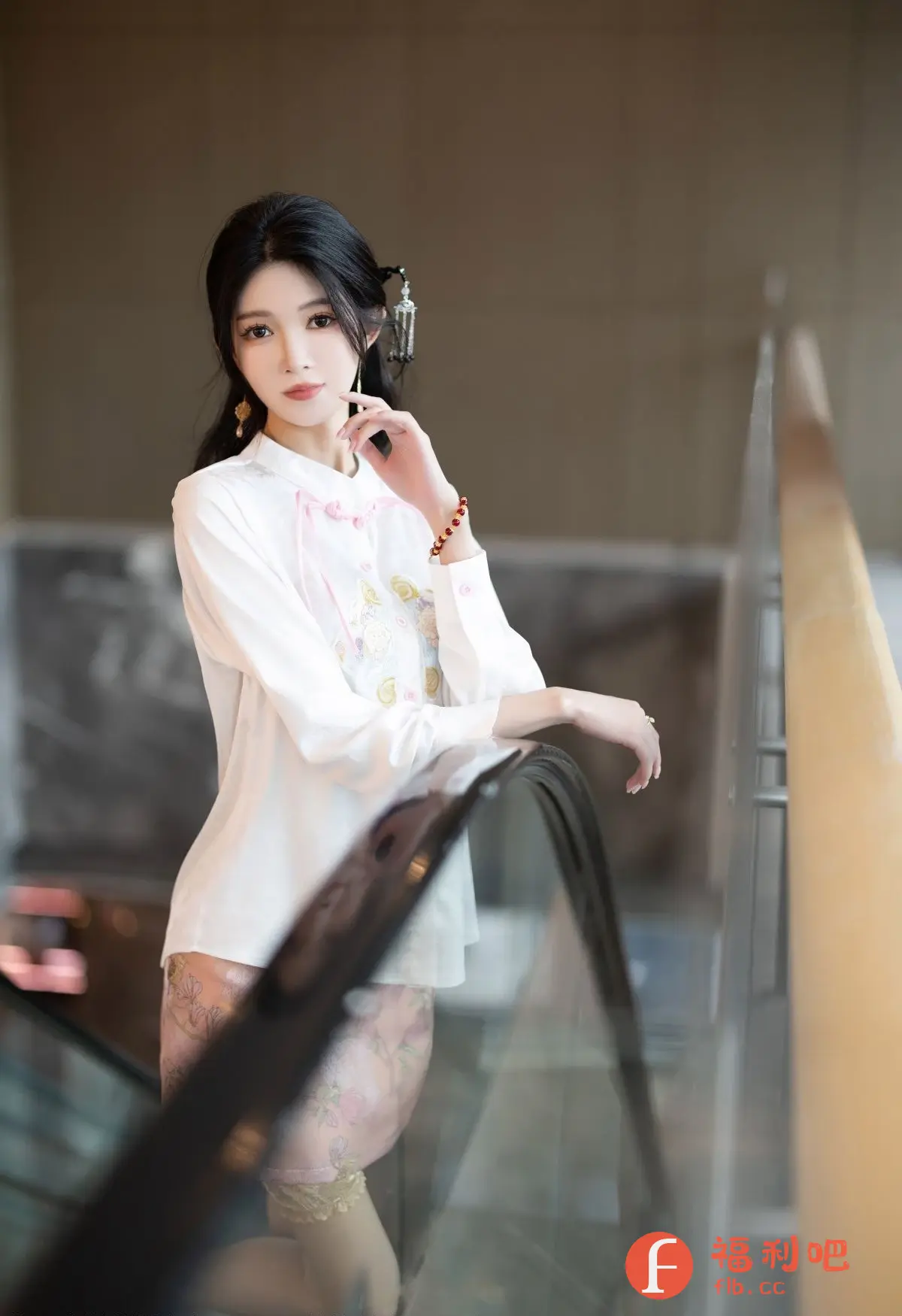 这张照片是一位穿着精致的美女的私房写真。她身穿一件带有精美刺绣的白色衬衫,搭配粉色花纹的裙子,整体造型典雅而时尚。她的头发盘起,配有古典的发饰,更增添了几分东方韵味。她站在扶梯旁,一手轻轻搭在扶手上,一手微微抬起,眼神充满魅力,姿态优雅迷人。整个画面光线柔和,背景简洁,突出了美女的精致妆容和优雅气质,营造出一种唯美浪漫的氛围。