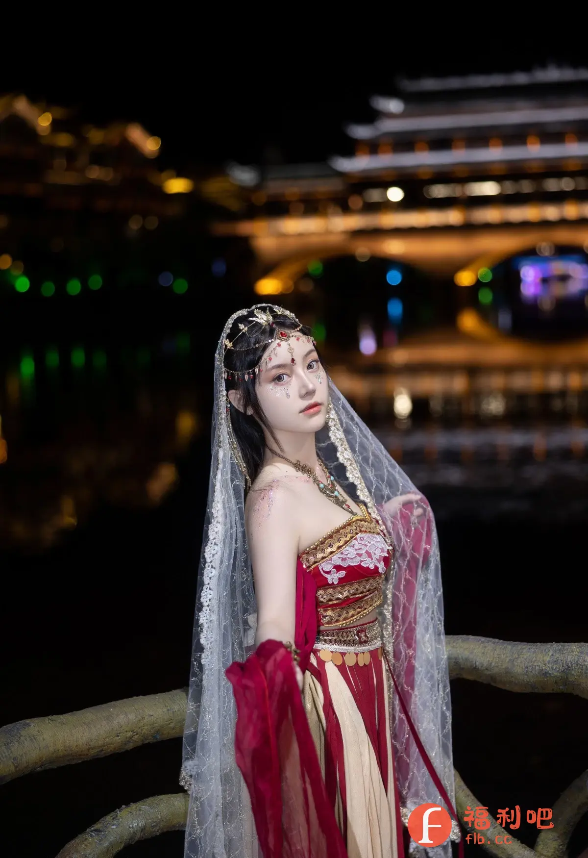 这张照片呈现出一位身着华丽民族服饰的美丽女子,她站在一个充满浪漫气息的夜景之中。女子身穿带有红色和金色元素的精致服装,配有繁复的头饰和面纱,彰显出一种古典而神秘的美感。她的妆容精致,眼神略带忧郁,仿佛是从古代画卷中走出来的美人。
背景是朦胧的夜景,灯光闪烁,倒映在平静的水面上,营造出一种梦幻般的氛围。女子站在一个古朴的桥梁或栏杆旁,更增添了画面的历史感和文化底蕴。整体构图和谐,色彩对比鲜明,突出了人物的美丽和背景的浪漫。这是一张极具艺术感的照片,充满了东方韵味和古典气息。