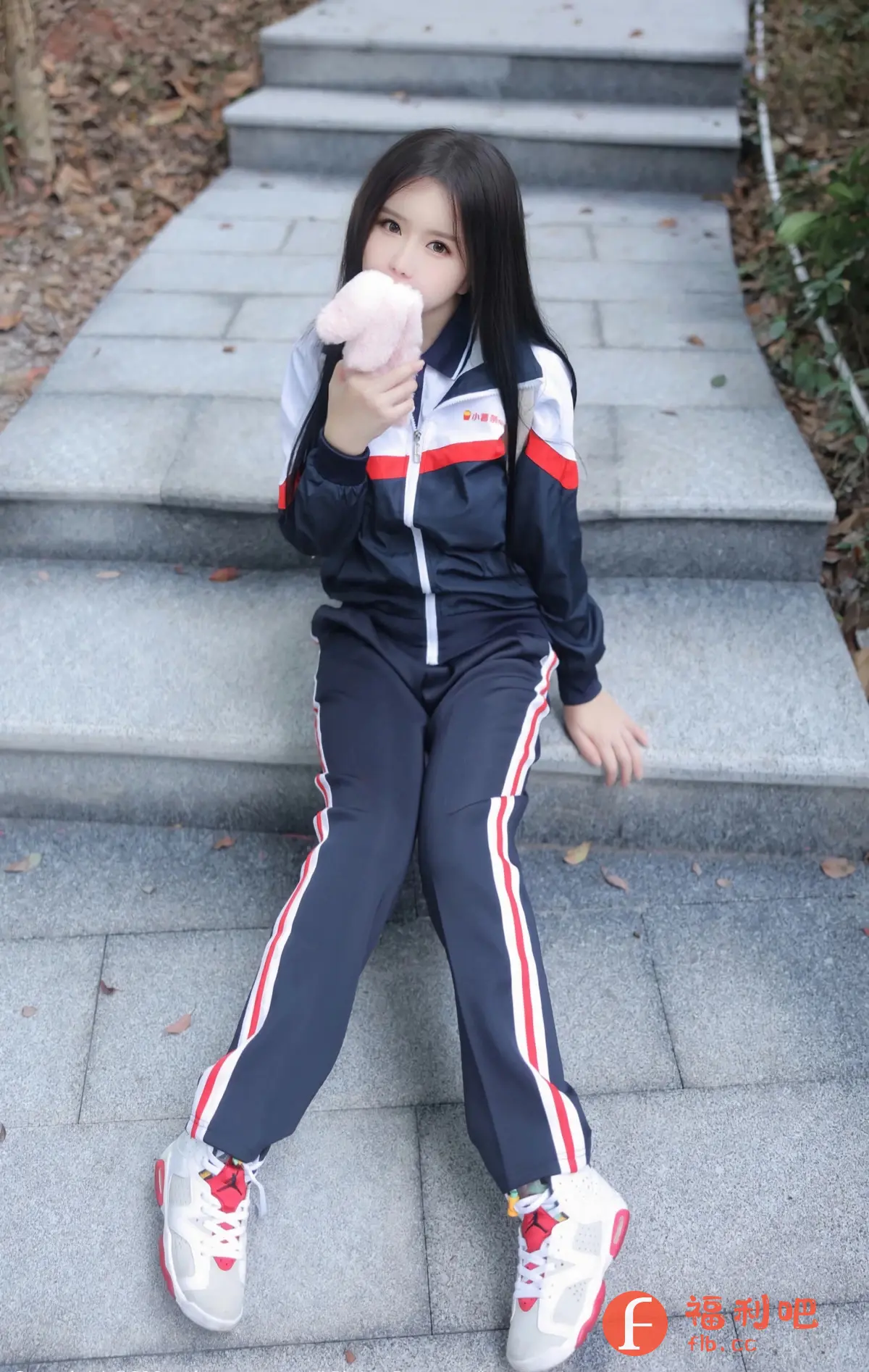 这是一个美女的私房写真照片,她正在摆放一个橙色的毛线玩具猫。她的衣服是黑色和白色的,让她看起来非常时髦。她的手腕上还戴着一个手表,显示她的时间和时钟。她的笑容和姿态表现出她的愉悦和自信。