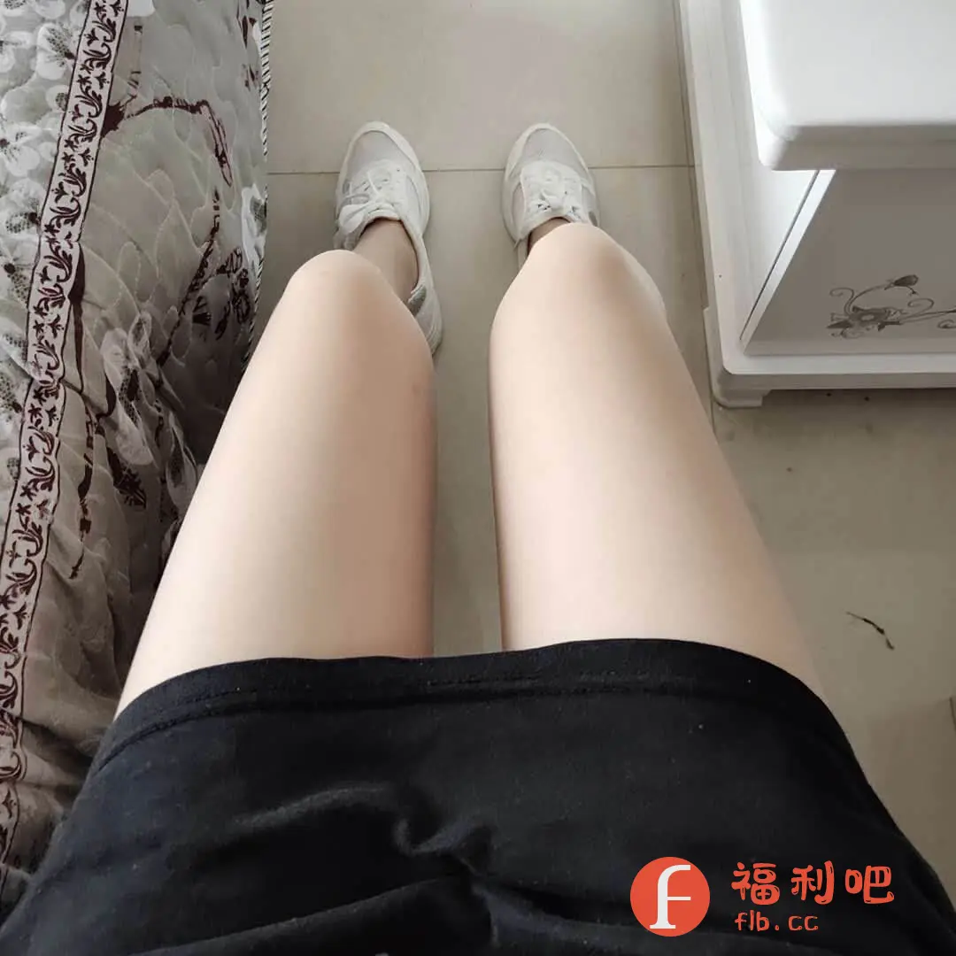这是一张女性视角的自拍,可能是某电商平台的买家秀。画面中,拍摄者坐在室内,双腿并拢,穿着黑色短裙,脚上穿着一双白色运动鞋,鞋子款式简约休闲。背景中可以看到部分带有花纹的床品和白色的家具,整个画面光线充足,色彩柔和。从拍摄角度来看,应该是坐在床上或沙发上,向下拍摄自己的双腿和鞋子,整体感觉比较轻松随意,可能是在展示新买的鞋子或裙子。这种类型的照片在电商平台上很常见,买家会通过分享自己的穿搭效果来帮助其他消费者更好地了解商品。