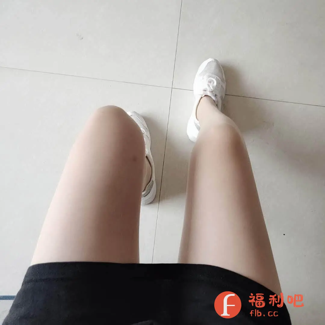 这张图片展示了一个年轻女性的视角,可能是她本人拍摄的。画面中心是她笔直的双腿,穿着肉色丝袜,肤色白皙均匀。她穿着一件黑色的短裙,裙子的边缘清晰可见。脚上穿着一双银色的运动鞋,款式休闲时尚。背景是白色瓷砖地面,瓷砖纹理简洁。整体画面简洁明快,重点突出了腿部和穿着,给人一种清新活力的感觉。风格偏向日常,可能是在室内拍摄的。图片的构图角度是从上往下俯视,视角独特,更容易吸引眼球。适合用于服装、鞋子、丝袜等产品的展示和推广,特别是强调修身效果和时尚感的商品。