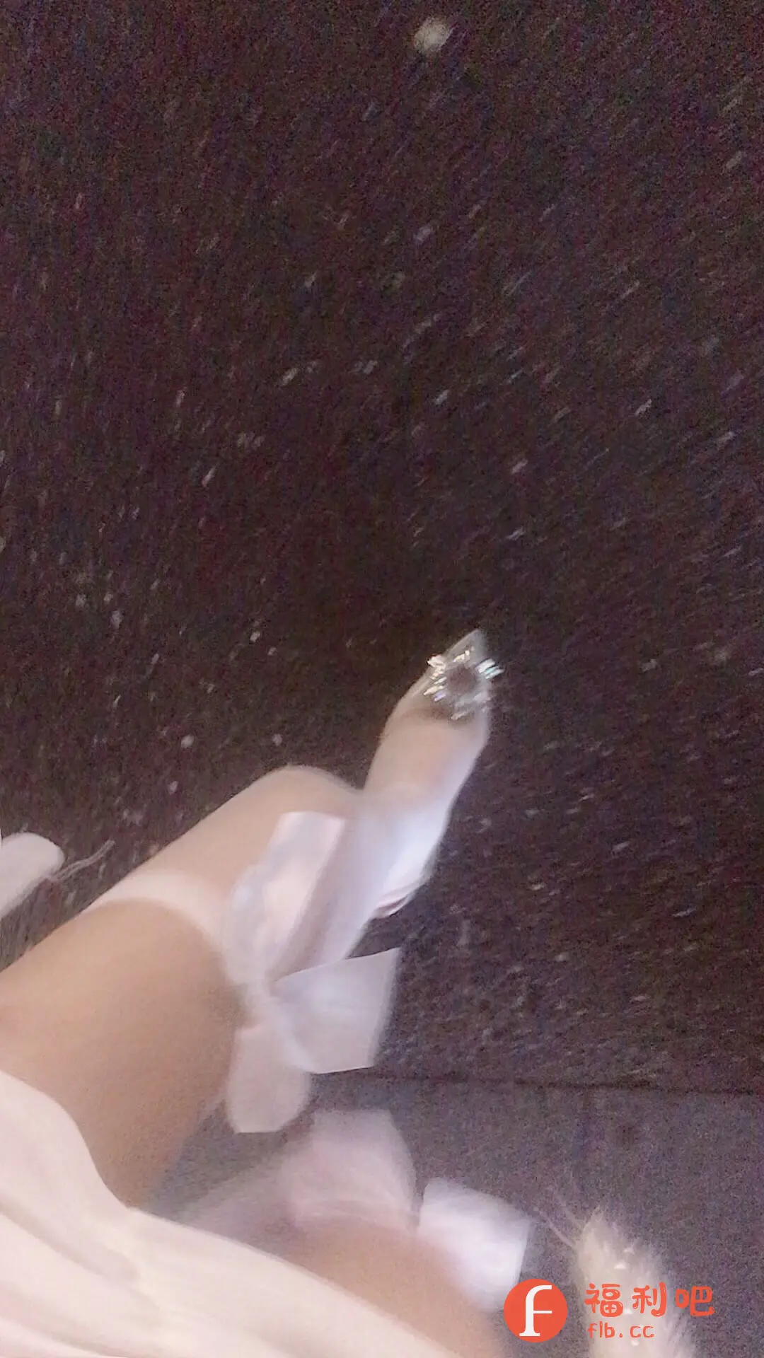 这是一张模糊的女性买家秀照片,主要展示了一双精致的高跟鞋。鞋子为浅色,带有亮片装饰,鞋面上装饰着白色的蝴蝶结,显得非常仙气和优雅。照片背景为深色,可能是在室内拍摄。整体风格比较梦幻和浪漫,适合用于展示婚鞋、礼服鞋或日常搭配的时尚单品。模糊的拍摄手法可能有意营造朦胧的美感,但也可能影响了对鞋子细节的清晰度。这张照片可能会吸引喜欢公主风、仙女风的女性消费者,或者正在寻找婚礼或特殊场合鞋子的顾客。