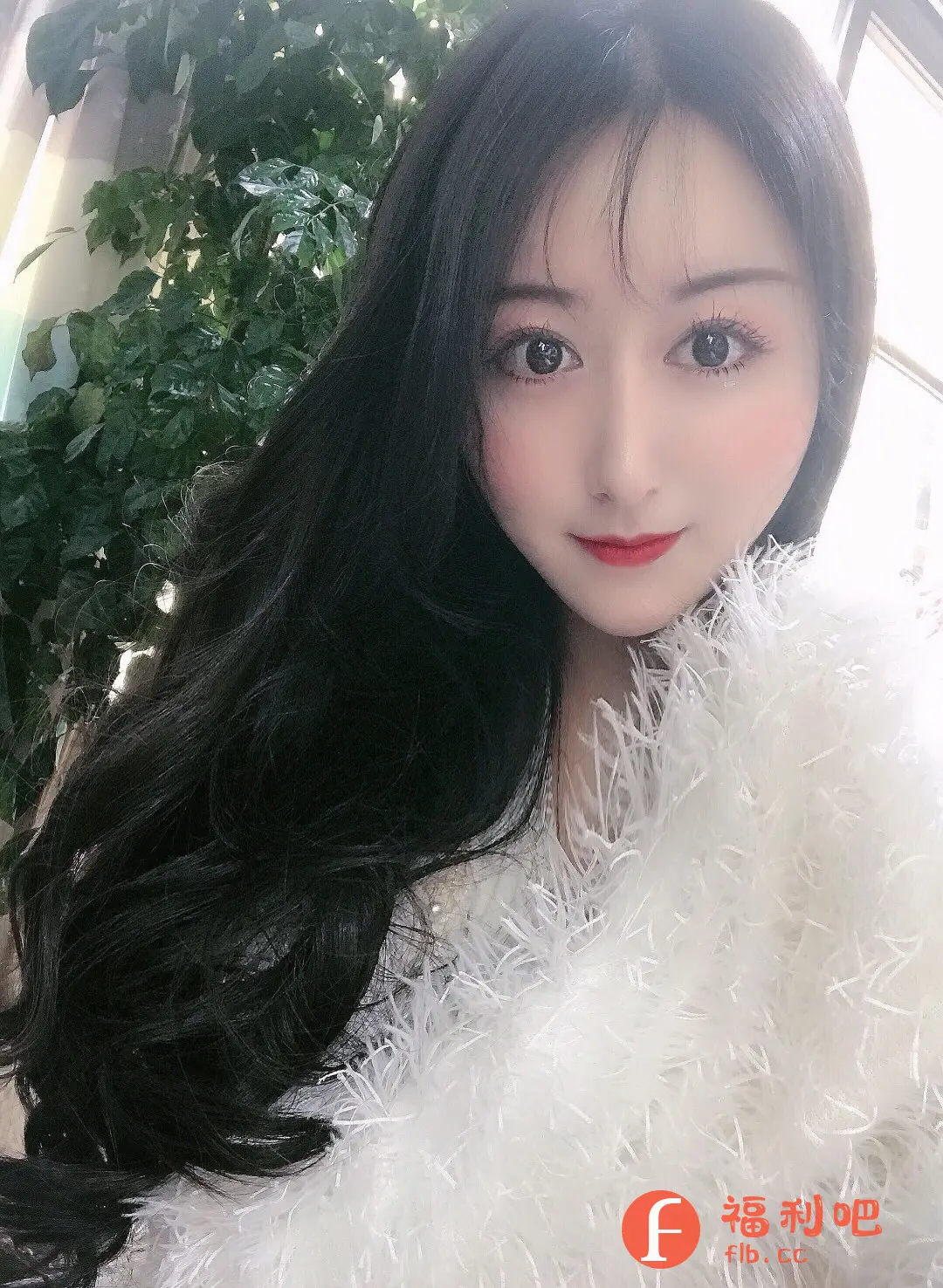 这张图展示了一位美丽的亚洲女性,她拥有乌黑亮丽的长发,柔顺地披在肩上。精致的妆容突显了她水汪汪的大眼睛,以及红润的嘴唇和脸颊,整体造型显得十分甜美可人。她身穿一件白色毛绒外套,更衬托出她的肤色白皙。背景中可以看到绿色的植物,可能是在室内或靠近窗户的位置拍摄的。这张照片非常适合作为某宝服装或美妆产品的买家秀,尤其适合宣传发色、口红、腮红、美瞳或白色毛绒外套等商品,可以吸引追求甜美风格的年轻女性消费者。