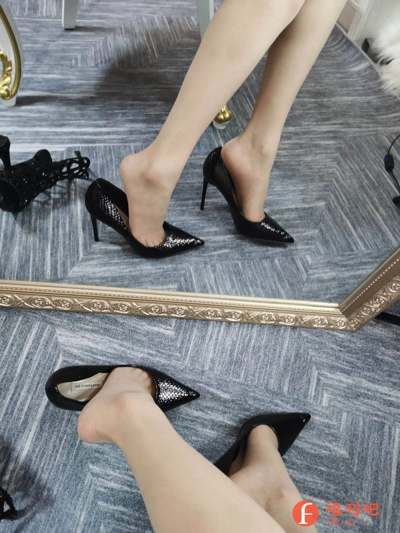 这张图片展示了一位美女在某宝上购买的黑色高跟鞋的买家秀。她穿着一双黑色尖头高跟鞋,鞋面带有蛇纹图案,尽显成熟性感。其中一只脚穿在鞋里,另一只脚微微抬起,展示了鞋子的设计和穿着效果。旁边还有一双鞋子以及一些饰品,可能是她搭配这双鞋子的配件。整体画面呈现出一种时尚、精致的感觉。背景是一面带有金色边框的镜子,镜子里也映出了她的脚和鞋子,增加了画面的层次感和趣味性。地面铺着带有几何图案的地毯,与高跟鞋的风格相呼应。 这张买家秀图片突出了高跟鞋的时尚感和美感,吸引了更多潜在买家的目光。