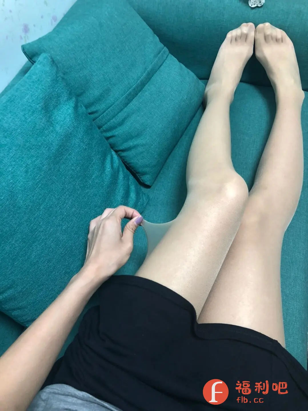 描述:这张照片展示了一位穿着黑色短裙的美女躺在绿色的沙发上。她修长的双腿穿着透明的丝袜,质感光滑,显得腿部线条更加优美。她的一只手轻轻拉扯着丝袜,似乎在展示丝袜的弹性或者薄透程度。整体构图简洁,焦点集中在美女的腿部和丝袜上,突出了商品的特点。沙发和靠枕的颜色与丝袜形成对比,更加衬托出丝袜的颜色和质感。这是一张典型的电商买家秀照片,旨在展示商品的上身效果和质量,吸引潜在买家。美女的姿态自然,展现了穿着该丝袜的舒适感和美观度。