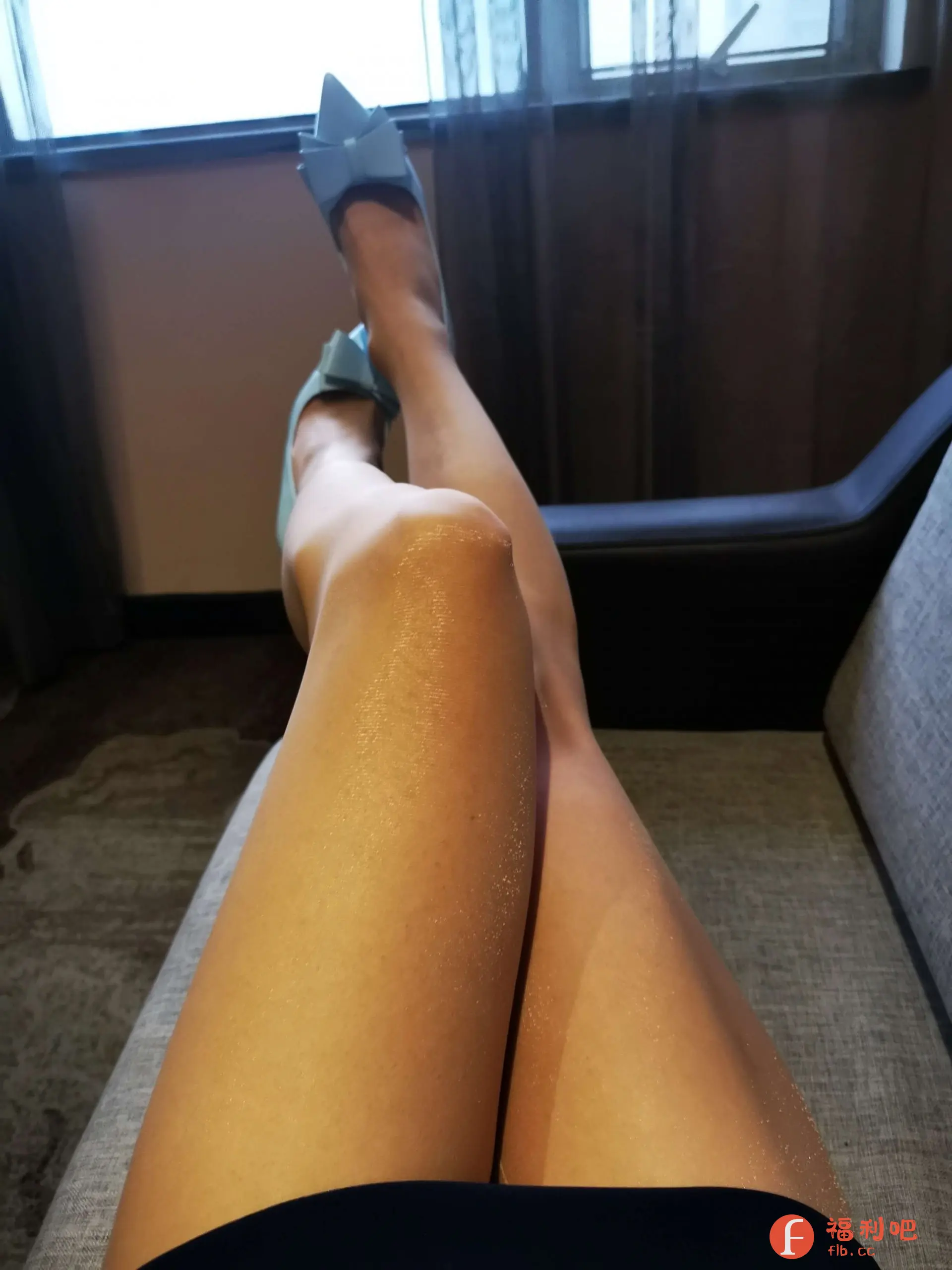 照片展示了一位穿着精致浅蓝色蝴蝶结高跟鞋的美女。她舒适地躺在沙发上,双腿交叠,显得轻松自在。高跟鞋的颜色清新淡雅,蝴蝶结设计增添了几分甜美气息。她的腿部皮肤光滑细腻,在光线的照射下泛着健康的光泽。整体画面给人一种优雅、时尚的感觉。背景是窗户和窗帘,营造出一种温馨的室内氛围。可以看出,美女对这次购物体验非常满意,并乐于分享她的美照。这双高跟鞋不仅提升了她的气质,也为她的休闲时光增添了一份精致感。