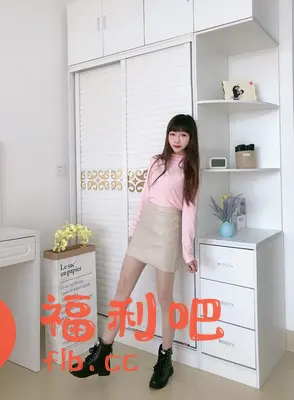 一位年轻时尚的亚洲女性站在衣柜前,展示她的穿搭。她身穿粉色高领长袖上衣,搭配米色皮质短裙和黑色系带马丁靴,整体造型甜美又带有一丝酷感。她的头发是深棕色,留着齐刘海,脸上化着精致的妆容,显得青春靓丽。背景是简洁的白色衣柜,旁边还有一个纸质购物袋和白色储物柜,营造出一种温馨舒适的氛围。这幅照片很可能是某宝买家秀,展示了服装的搭配效果和穿着者的个人魅力。