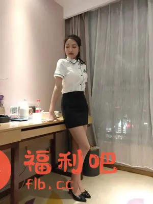这是一位身材姣好的亚洲女性在房间内的照片,她身穿一件白色短袖衬衫,搭配黑色短裙和黑色高跟鞋,整体造型简约干练,颇具职业感。衬衫设计简洁,细节处有黑色镶边,增添了时尚感。短裙展现了她修长的双腿,高跟鞋则提升了整体的气质。她倚靠在桌边,姿态优雅,背景是窗帘和城市夜景,营造出一种温馨而时尚的氛围。整体来看,这张照片可能是服装的买家秀,展现了服装的上身效果和搭配风格。