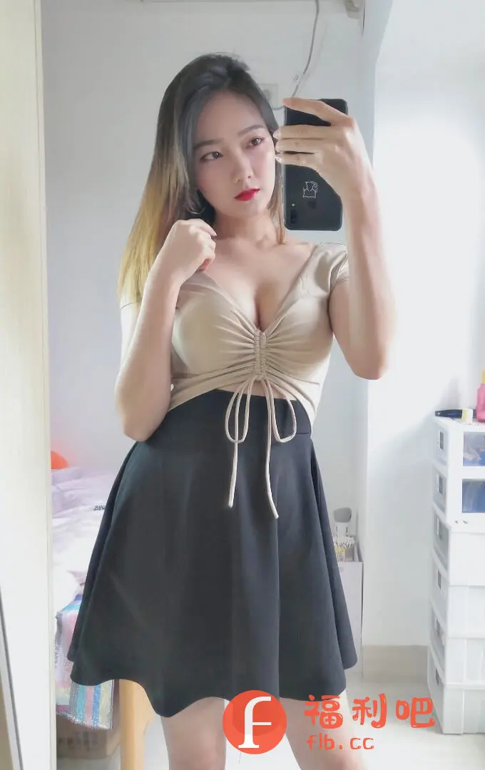 这位美女身穿一套时尚感十足的穿搭,正在对着镜子自拍,应该是在分享她的购物体验。她上身穿一件浅卡其色的收腰上衣,V领设计巧妙地凸显了颈部线条,收腰抽绳的设计更显身材,同时也增添了一丝俏皮感。下身搭配一条黑色A字短裙,经典的黑白搭配简约大方,A字裙摆能够很好地修饰腿型,显得双腿更加纤细修长。整体造型青春靓丽,凸显了她的好身材和时尚品味。背景是简约的室内环境,更衬托出美女的自信和美丽。这套穿搭无论是日常出街还是约会都非常适合,简单又不失精致,非常值得借鉴。